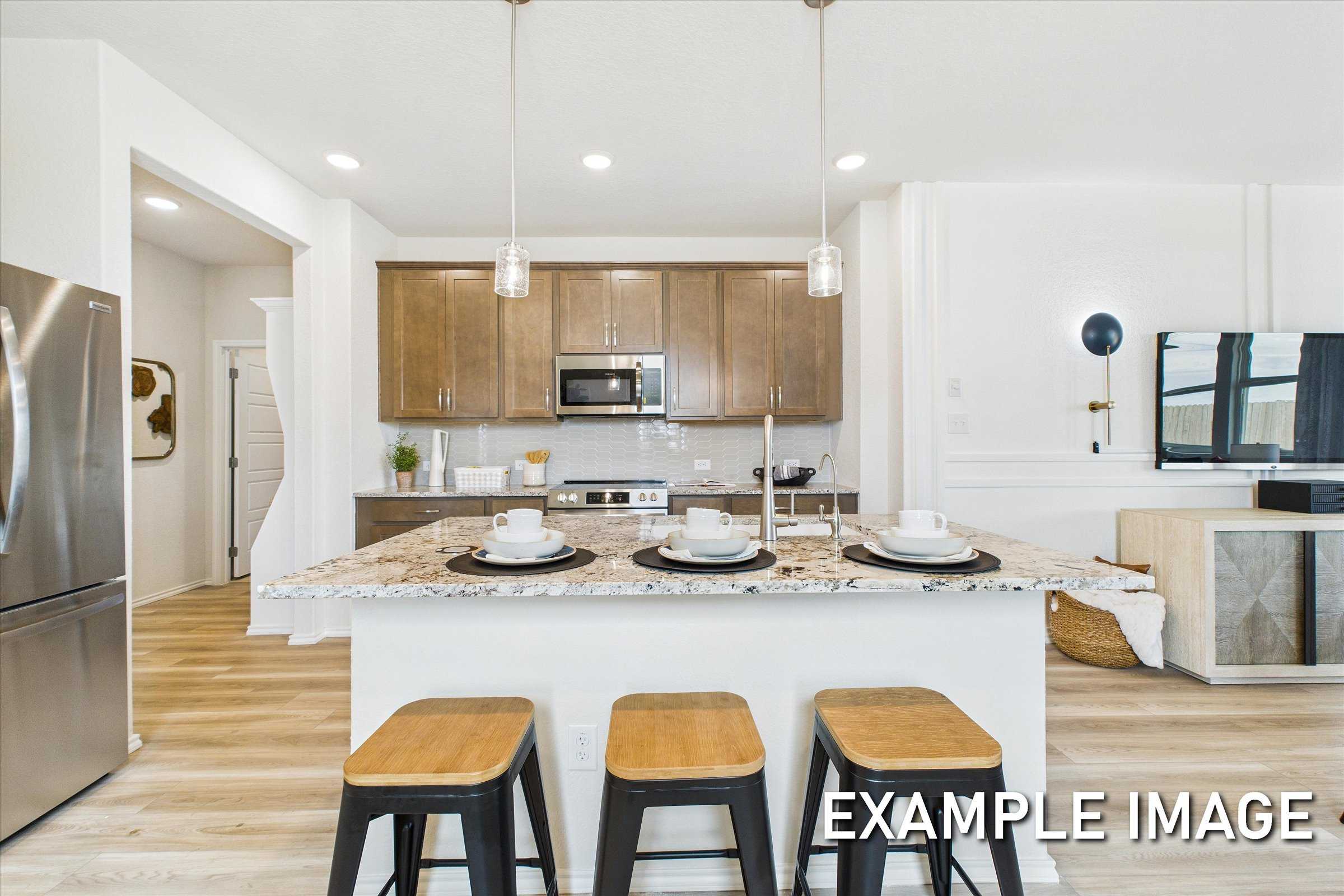 Spacious modern kitchen in The Brazos featuring large white island, shaker cabinets, stainless appliances, and open shelving