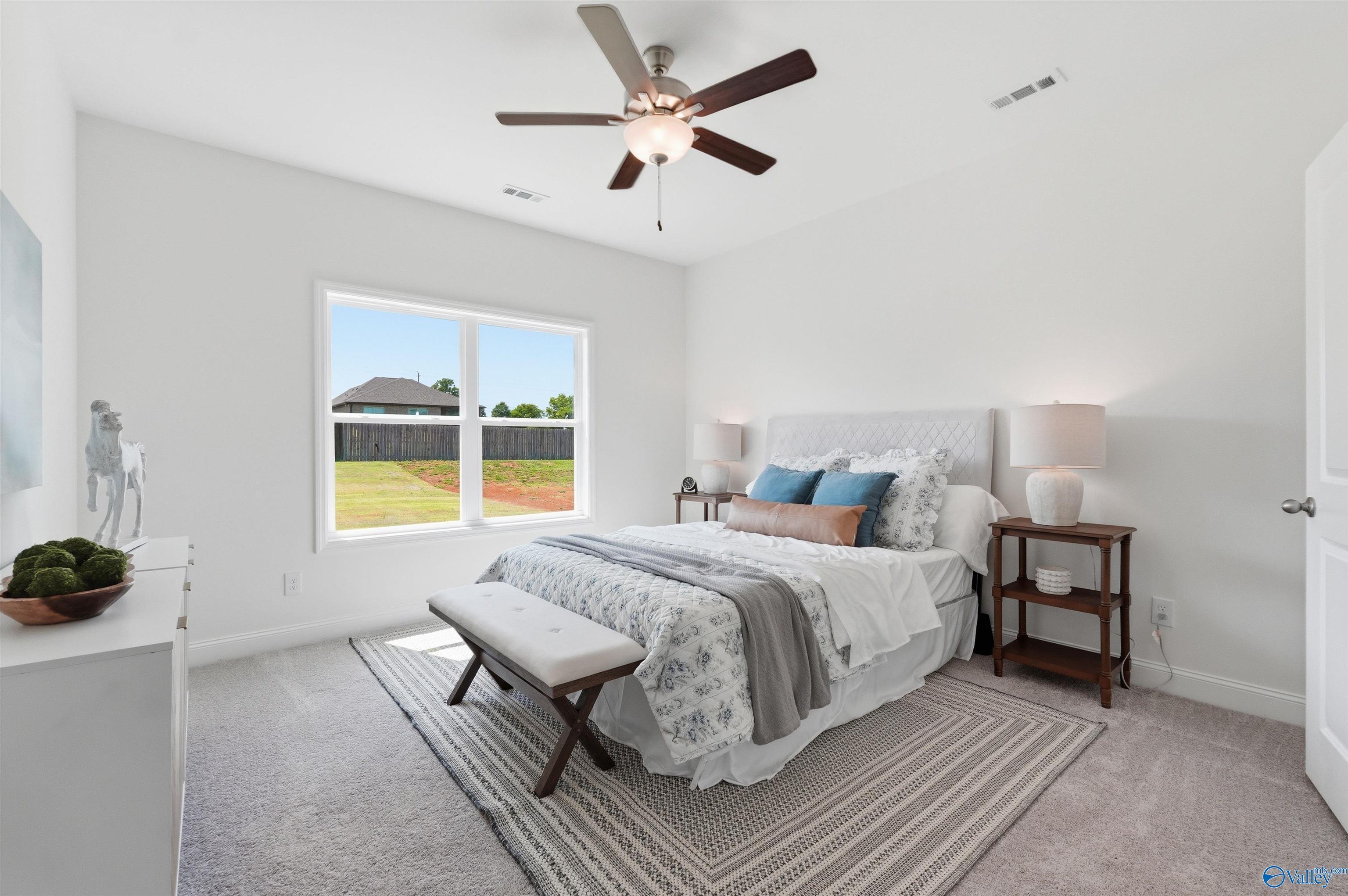 Bright bedroom with ceiling fan and plush carpet in The Franklin C floor plan at Lynn Meadows, Meridianville, Alabama.