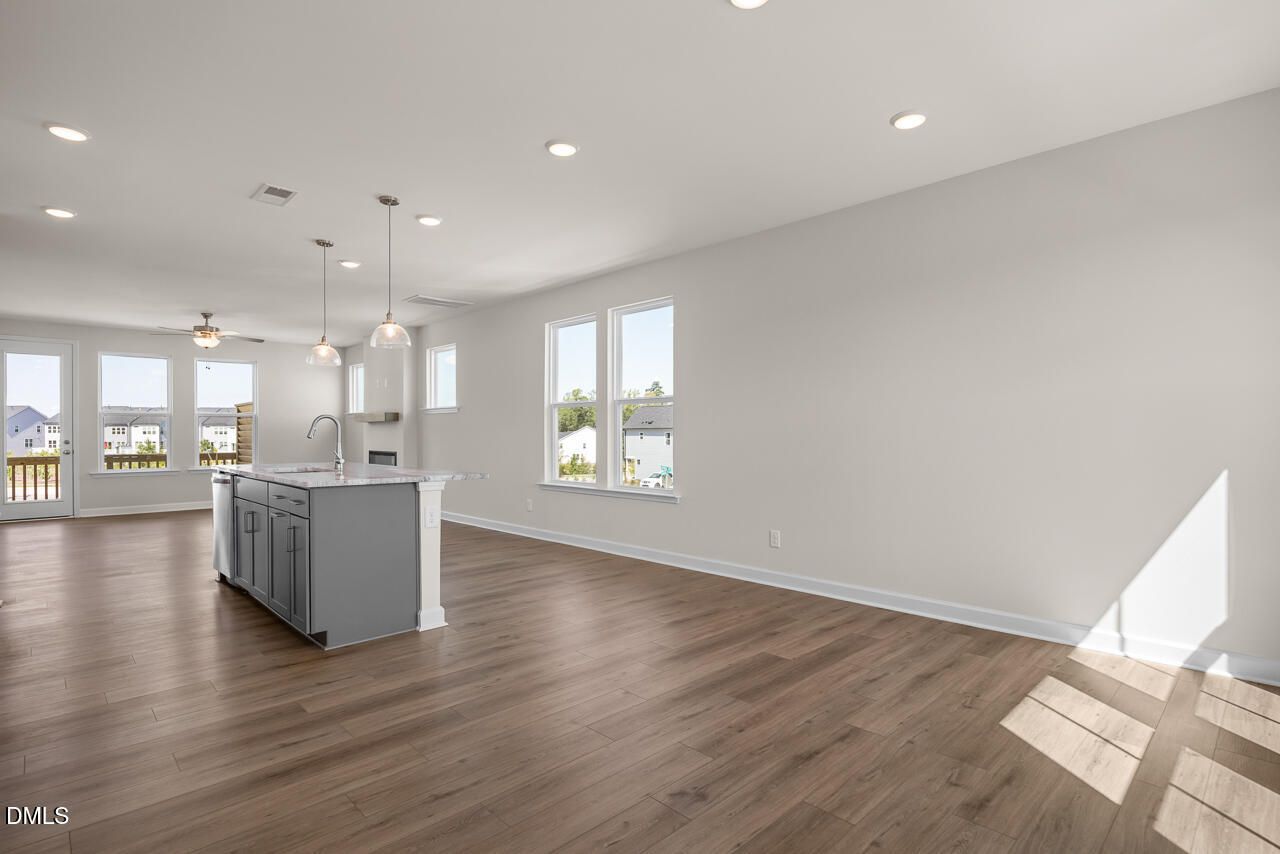 Open-concept kitchen with gray island and pendant lights in Davidson Homes Mitchell floor plan, Knightdale NC townhome