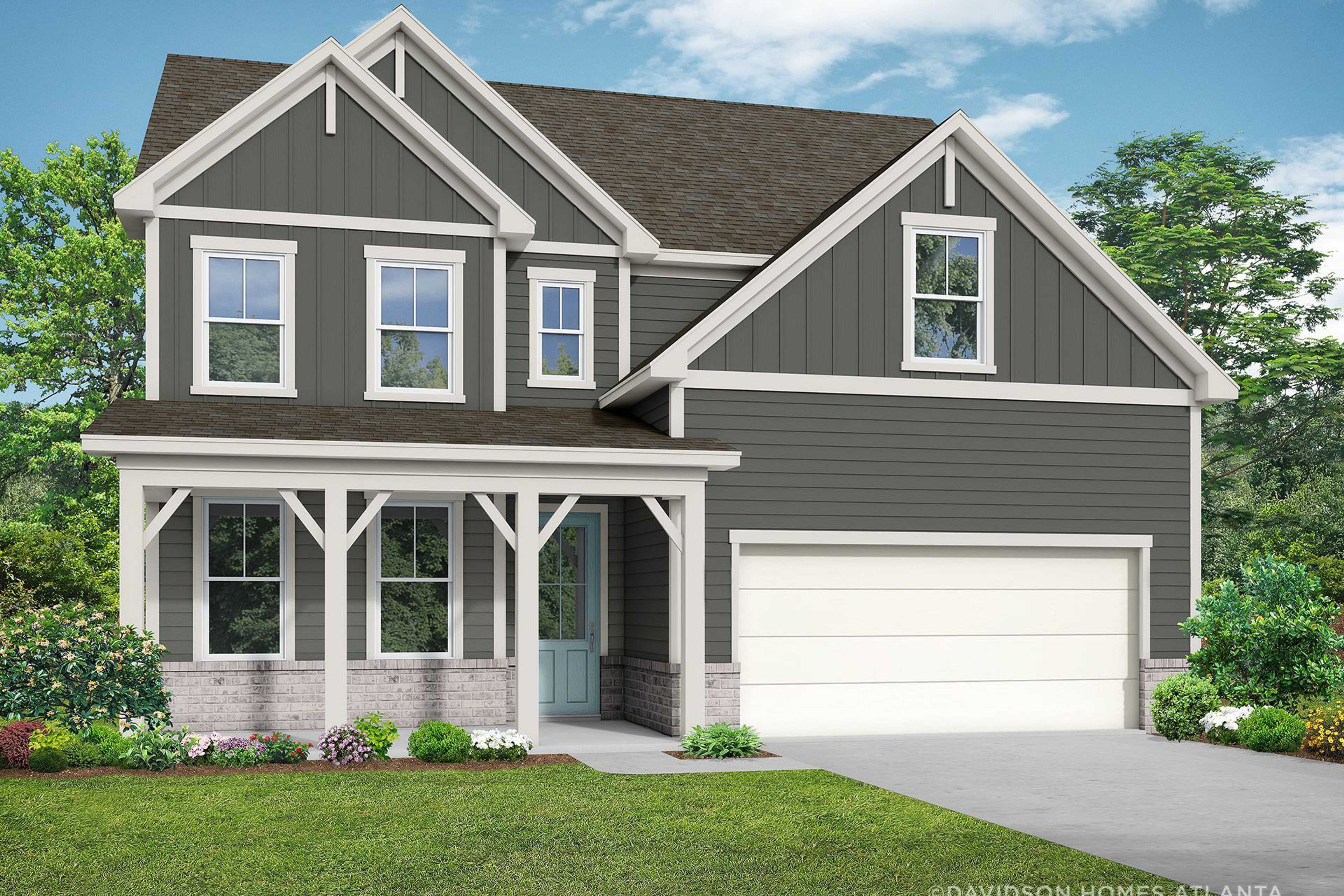 Two-story craftsman elevation of The Hickory B showcasing gray siding, covered porch, two-car garage, and lush landscaping in Hoschton