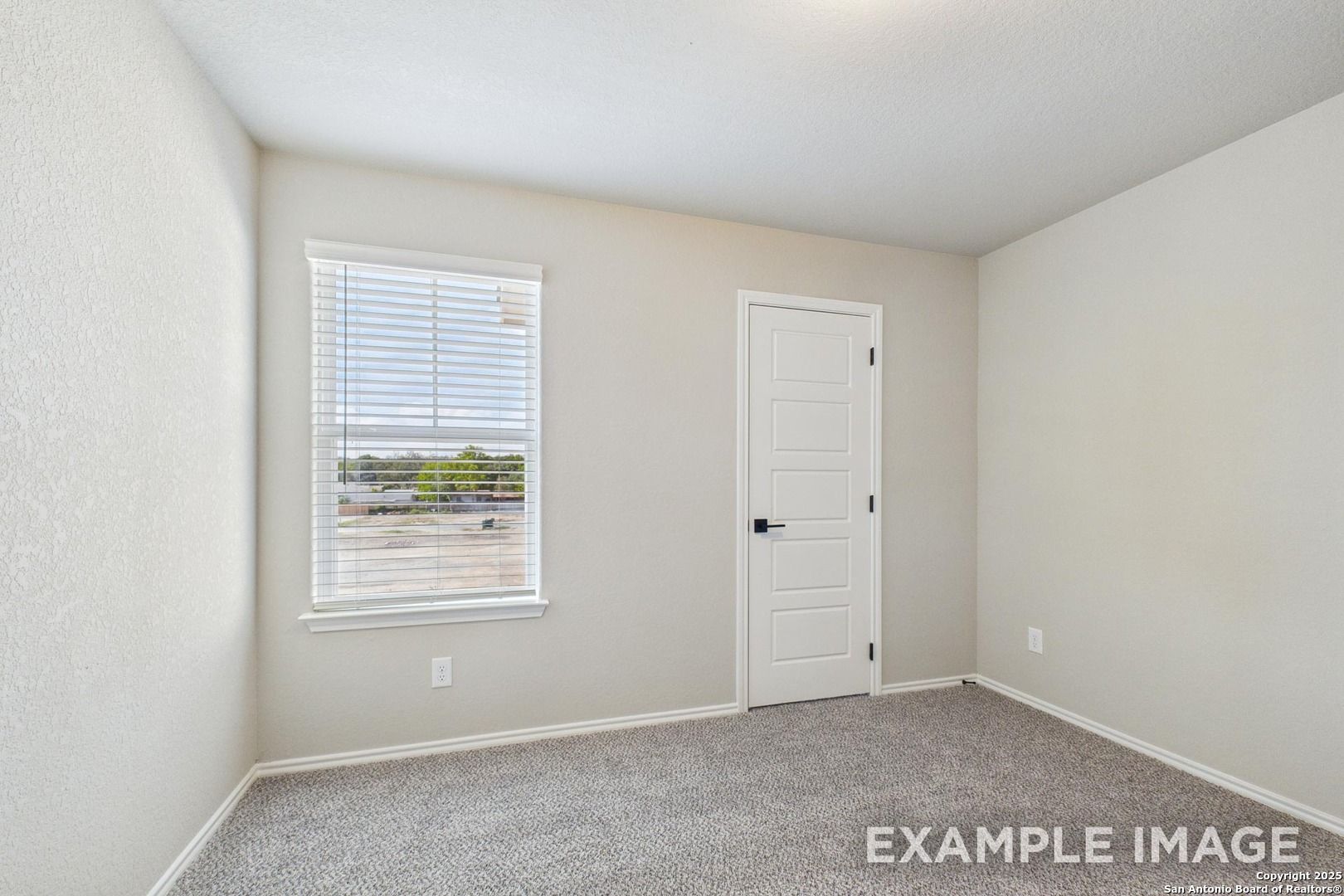 Bright secondary bedroom with beige walls, window blinds, and carpet in Davidson Homes The Charlotte A, San Antonio, Texas