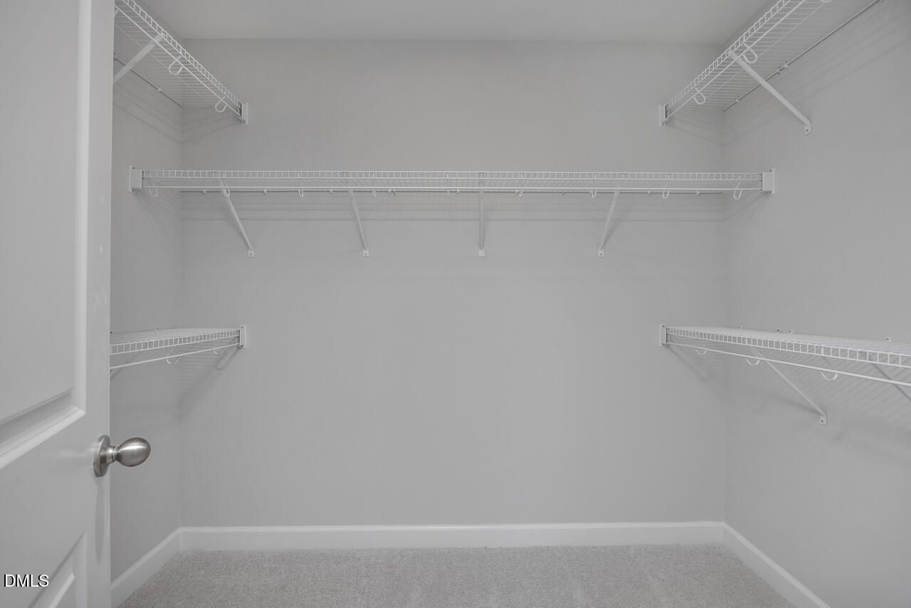 Walk-in closet with white wire shelving in The Adalynn B floor plan at Gregory Village in Lillington, North Carolina.