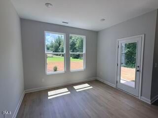 Bright breakfast nook with wood-style flooring and patio access in The Daphne D plan, Woodland Crossing, Zebulon, NC.