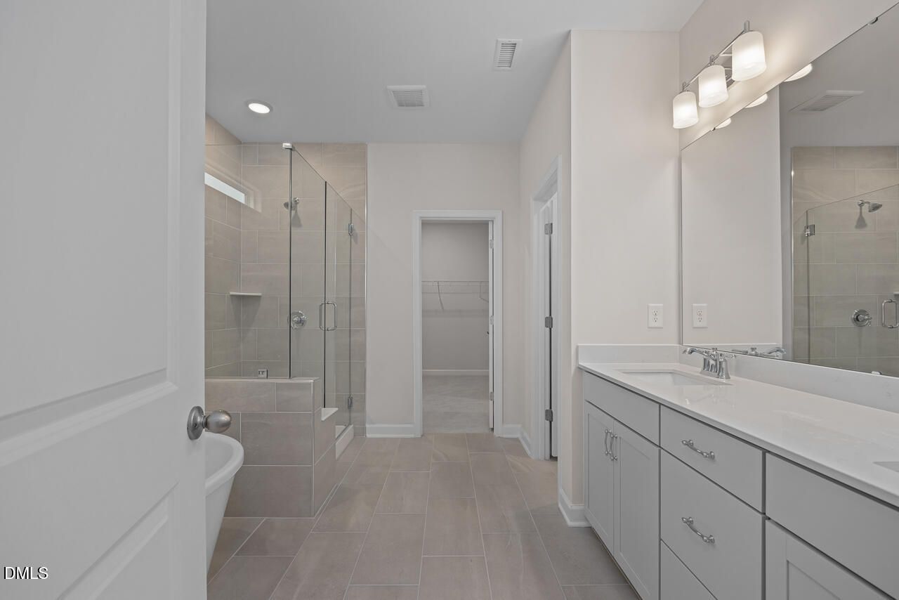 Modern master bathroom featuring glass shower enclosure and double vanity in Davidson Homes The Cypress D II, Angier, NC