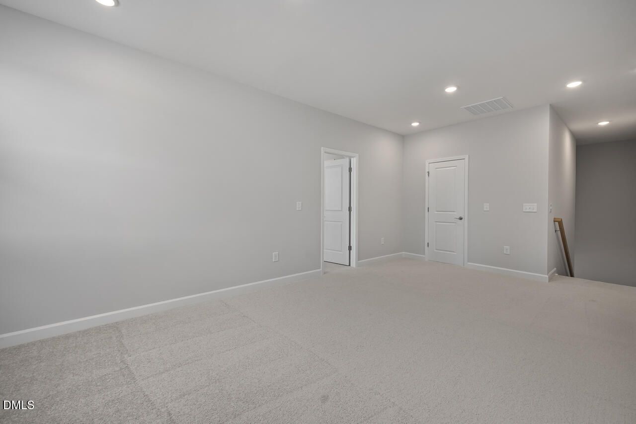 Spacious carpeted loft area in The Ashport L floor plan at Sage on North Main in Wake Forest, North Carolina.