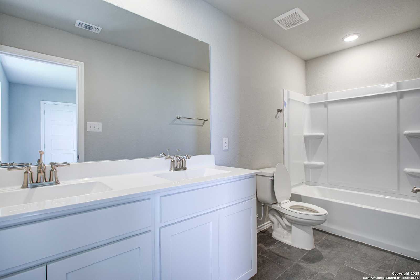 Modern bathroom featuring double vanity, bathtub, shower, and tile floor in Davidson Homes The Douglas G, San Antonio, Texas