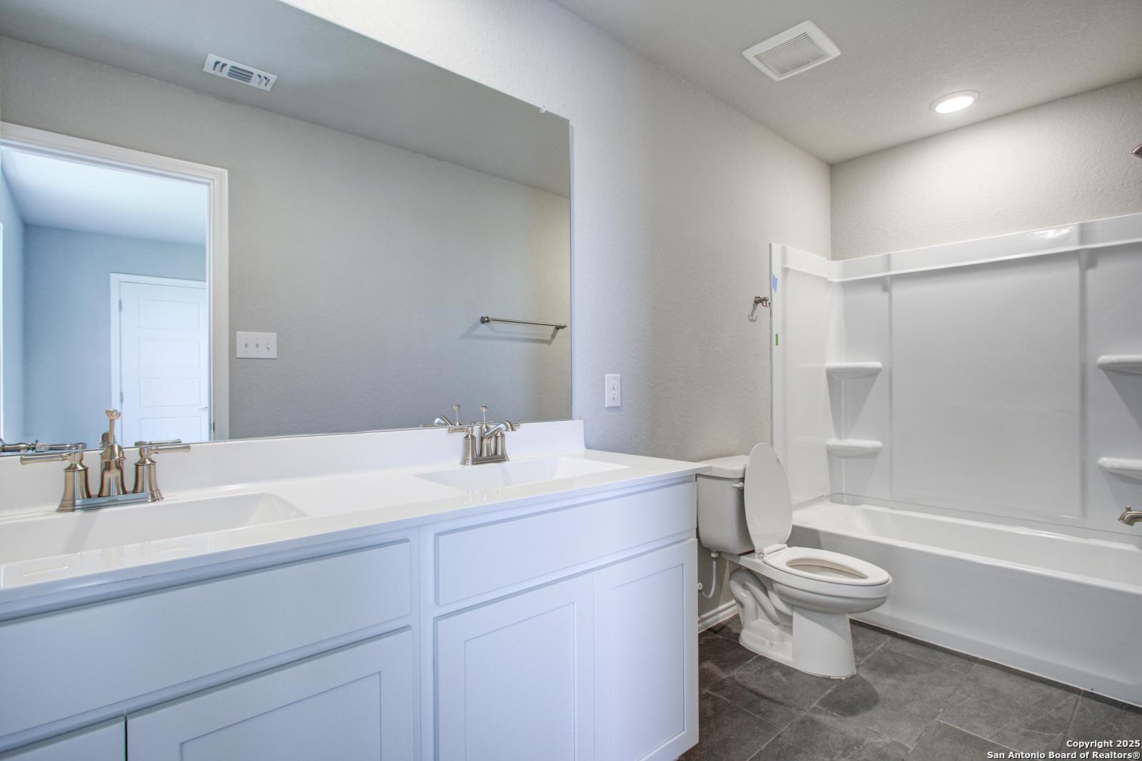 Modern bathroom featuring double vanity, bathtub, shower, and tile floor in Davidson Homes The Douglas G, San Antonio, Texas