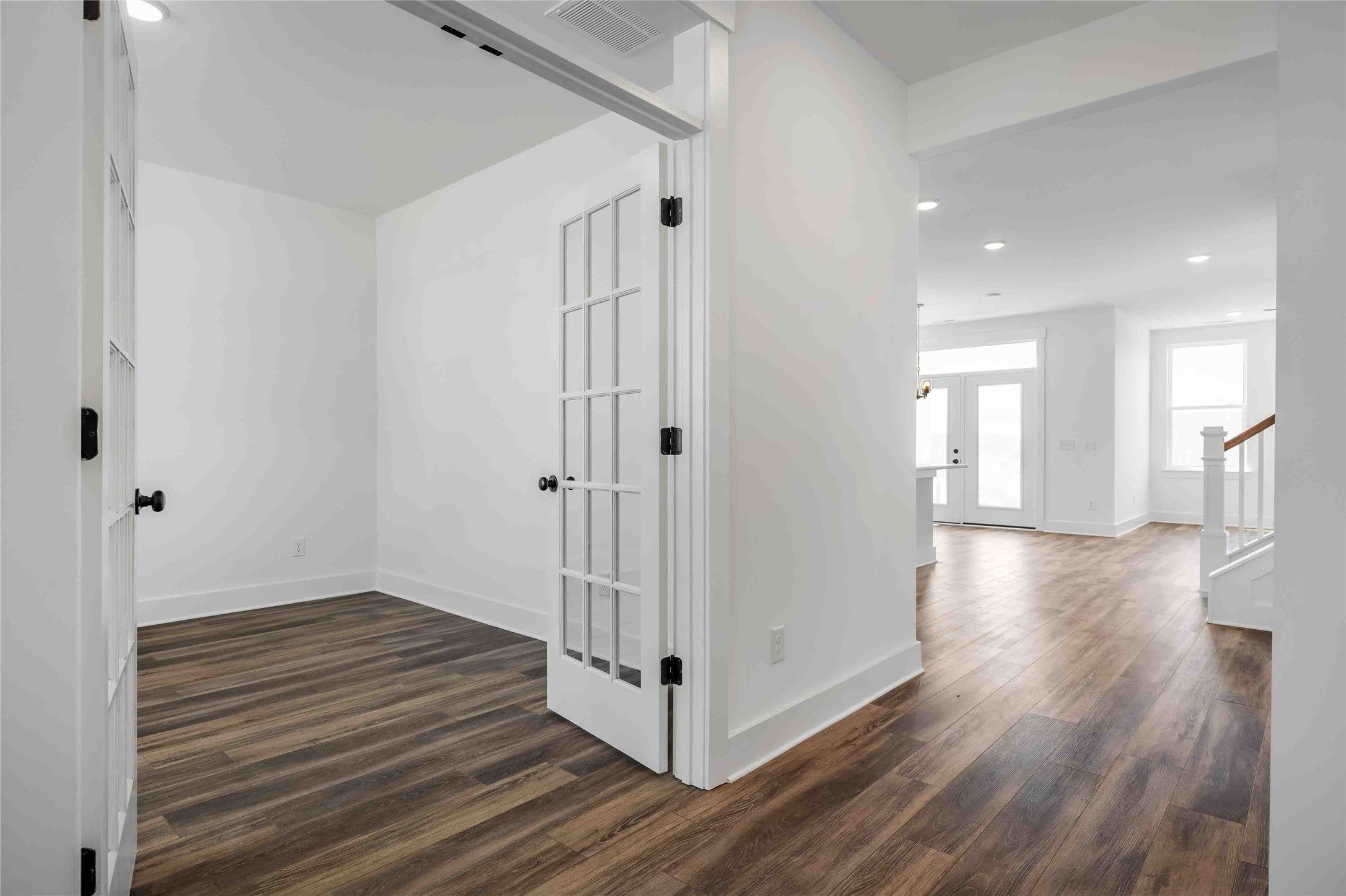 Bright home office with French doors and wood-look flooring in The Ash N floor plan at Parks at Foster Crossing, Anna, TX.