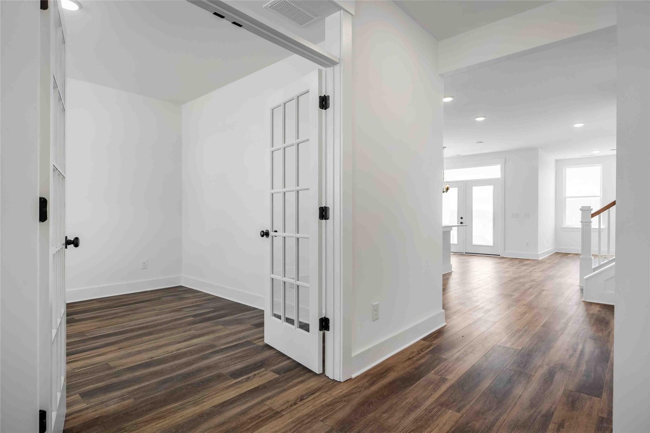 Home office with French doors and wood-look flooring in The Ash O floor plan by Davidson Homes in Heartland, Texas.