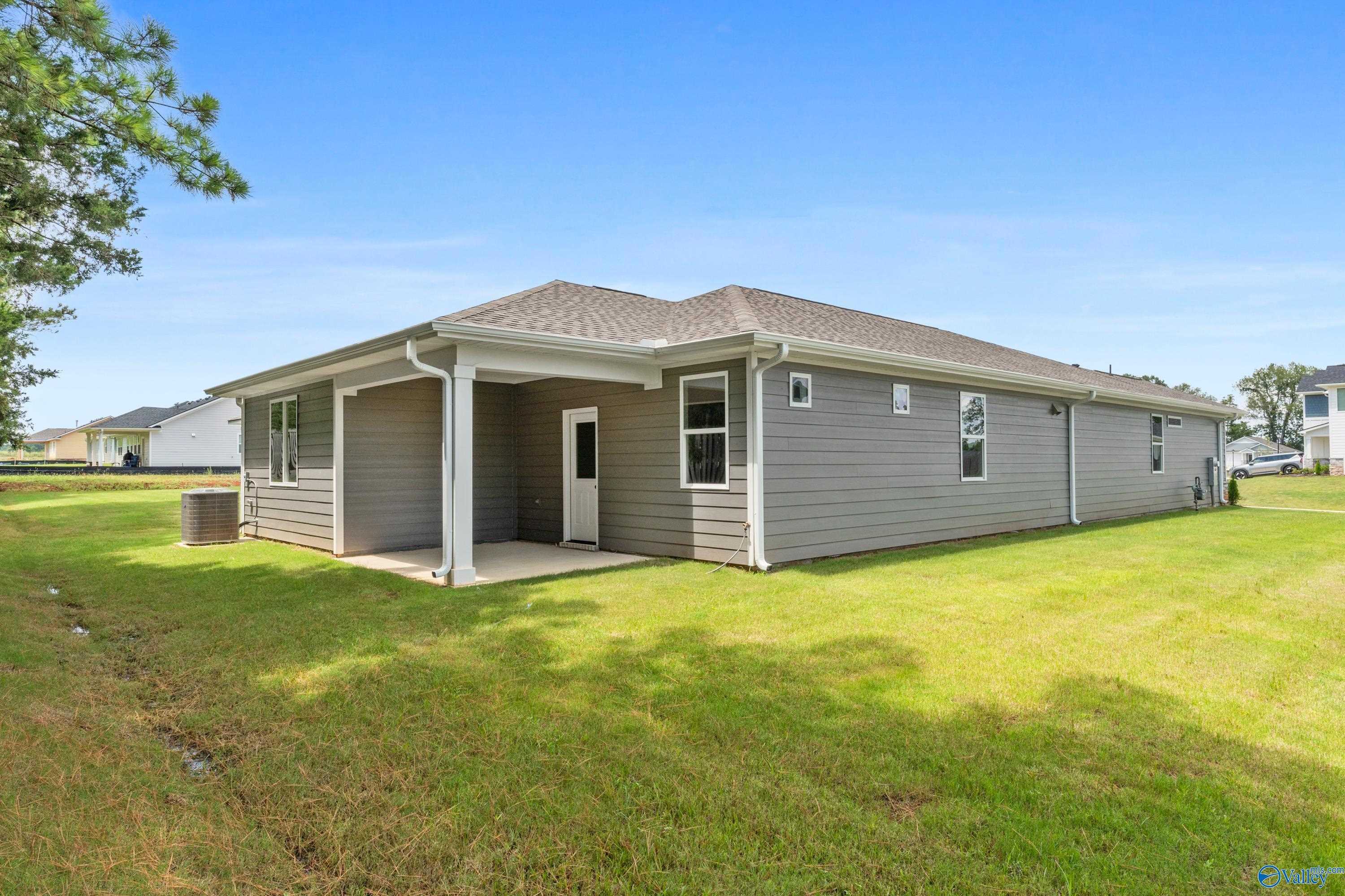 Side view of one-story Nantucket home with covered porch, gray siding, and green lawn in Evergreen Mill, Madison, Alabama
