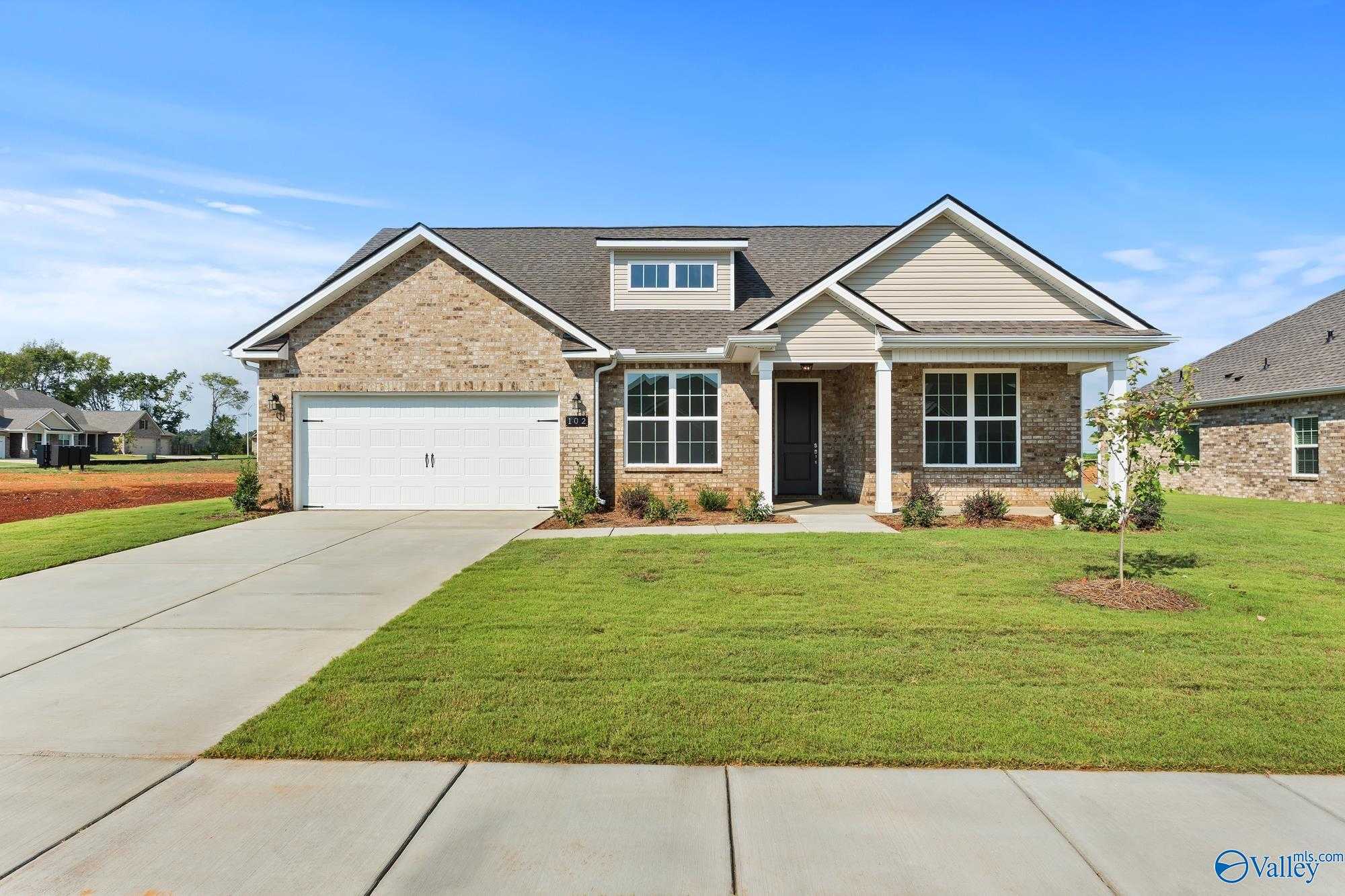 Charming brick ranch-style home with 2-car garage, front porch, and lush lawn in Pikes Ridge, Meridianville, Alabama
