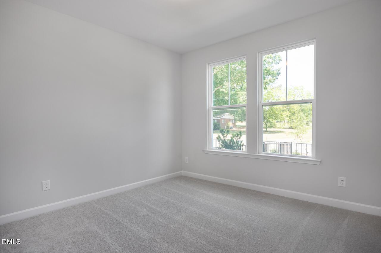 Bright, cozy bedroom with neutral grey walls and carpet in The Mitchell floor plan at Camden Park, Knightdale, NC.