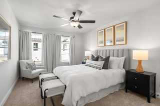 Spacious master bedroom in The Washington H townhome featuring king bed, ceiling fan, neutral decor, and large windows, Davidson Homes Marietta GA