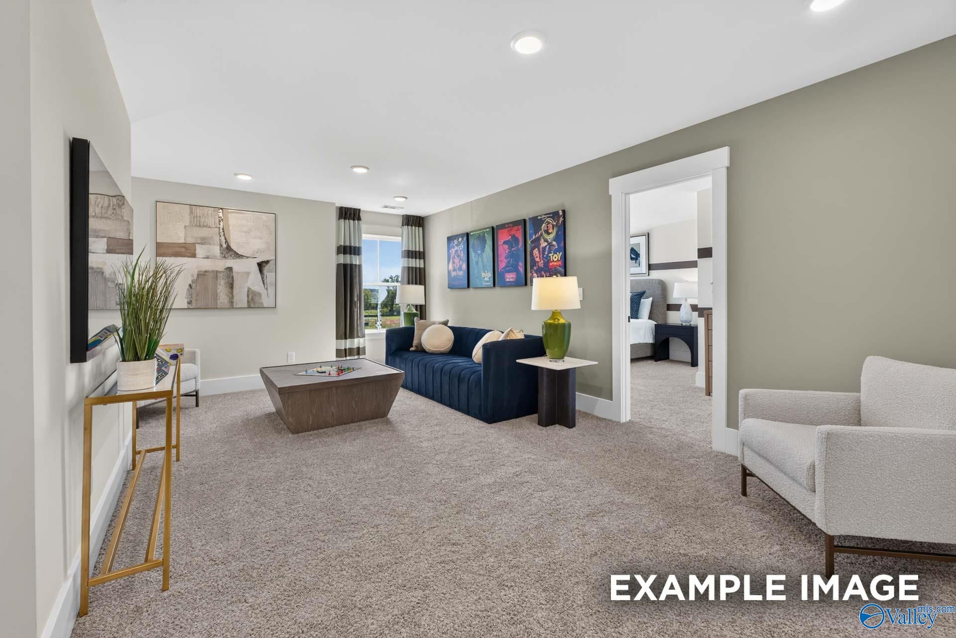 Spacious carpeted game room with navy sofa and movie posters in Davidson Homes Ashport K floor plan, Forest Glen, Hazel Green