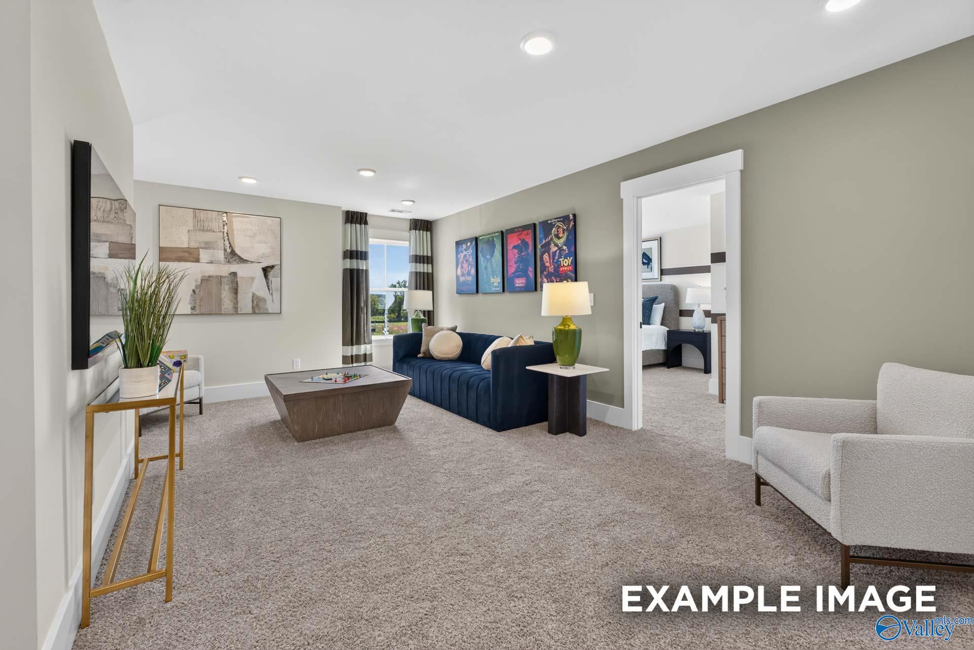 Spacious carpeted game room with navy sofa and movie posters in Davidson Homes Ashport K floor plan, Forest Glen, Hazel Green