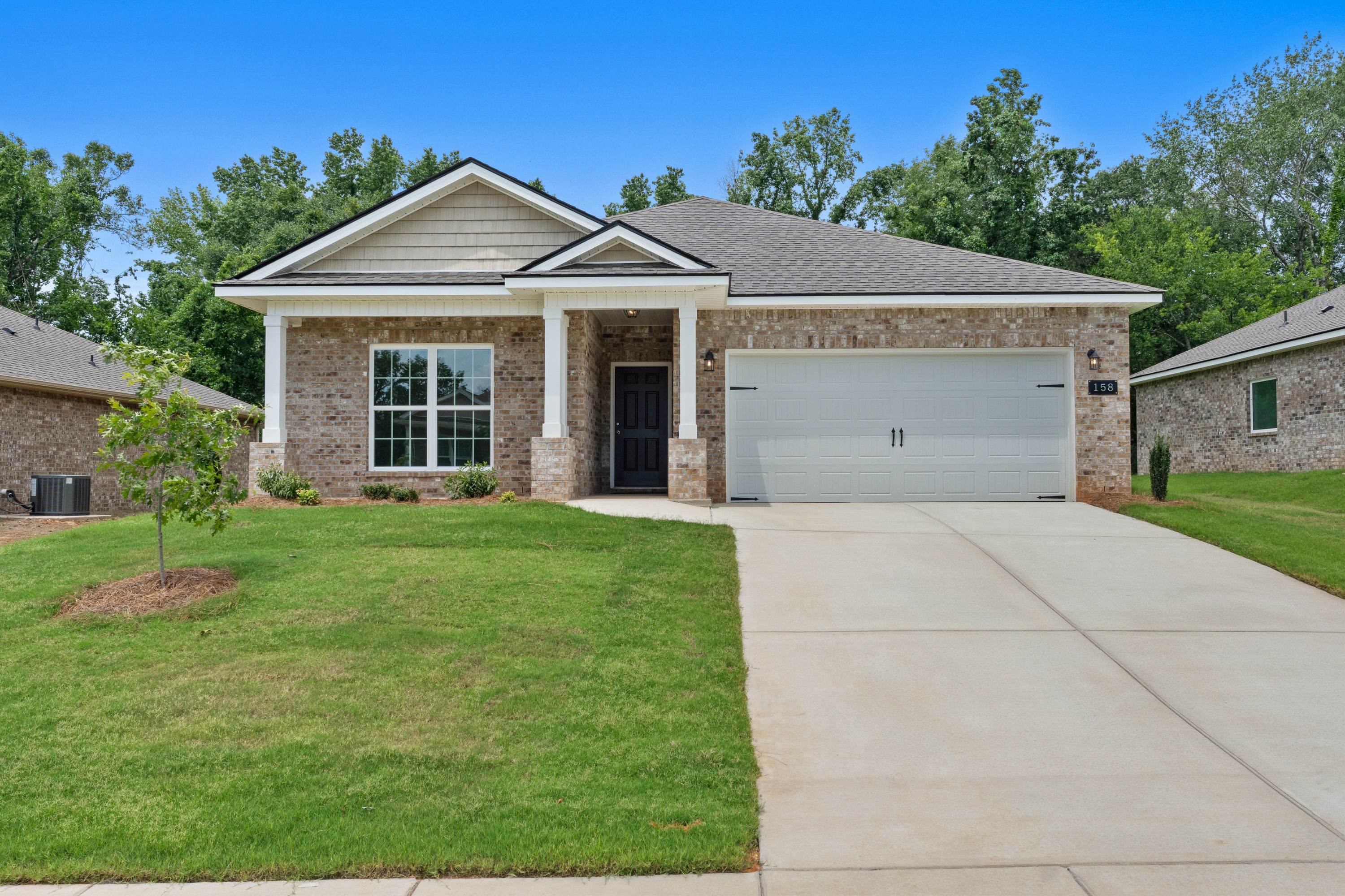 Single-story brick home exterior by Davidson Homes at Flint Meadows in New Market, Alabama with a two-car garage.