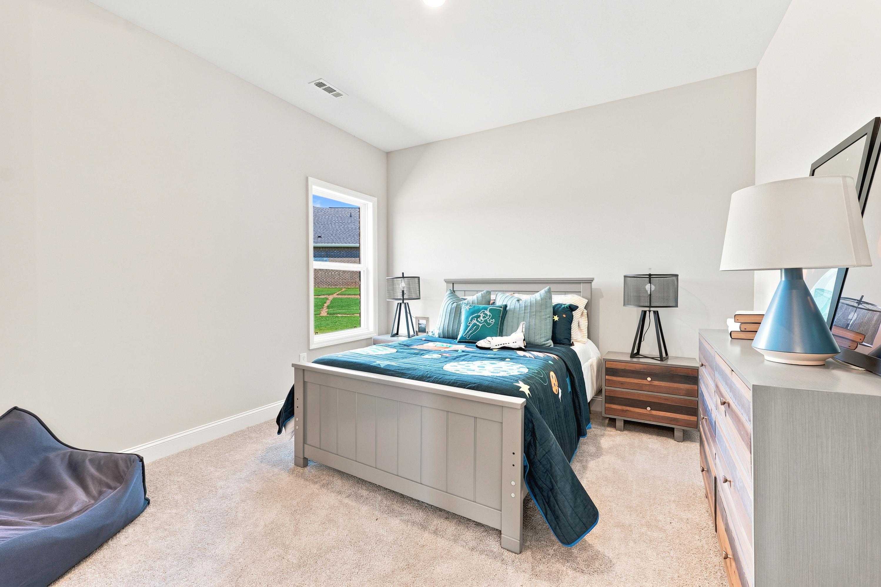 Spacious bedroom with space-themed bedding at Riverton Preserve in Huntsville, AL, built by Davidson Homes.