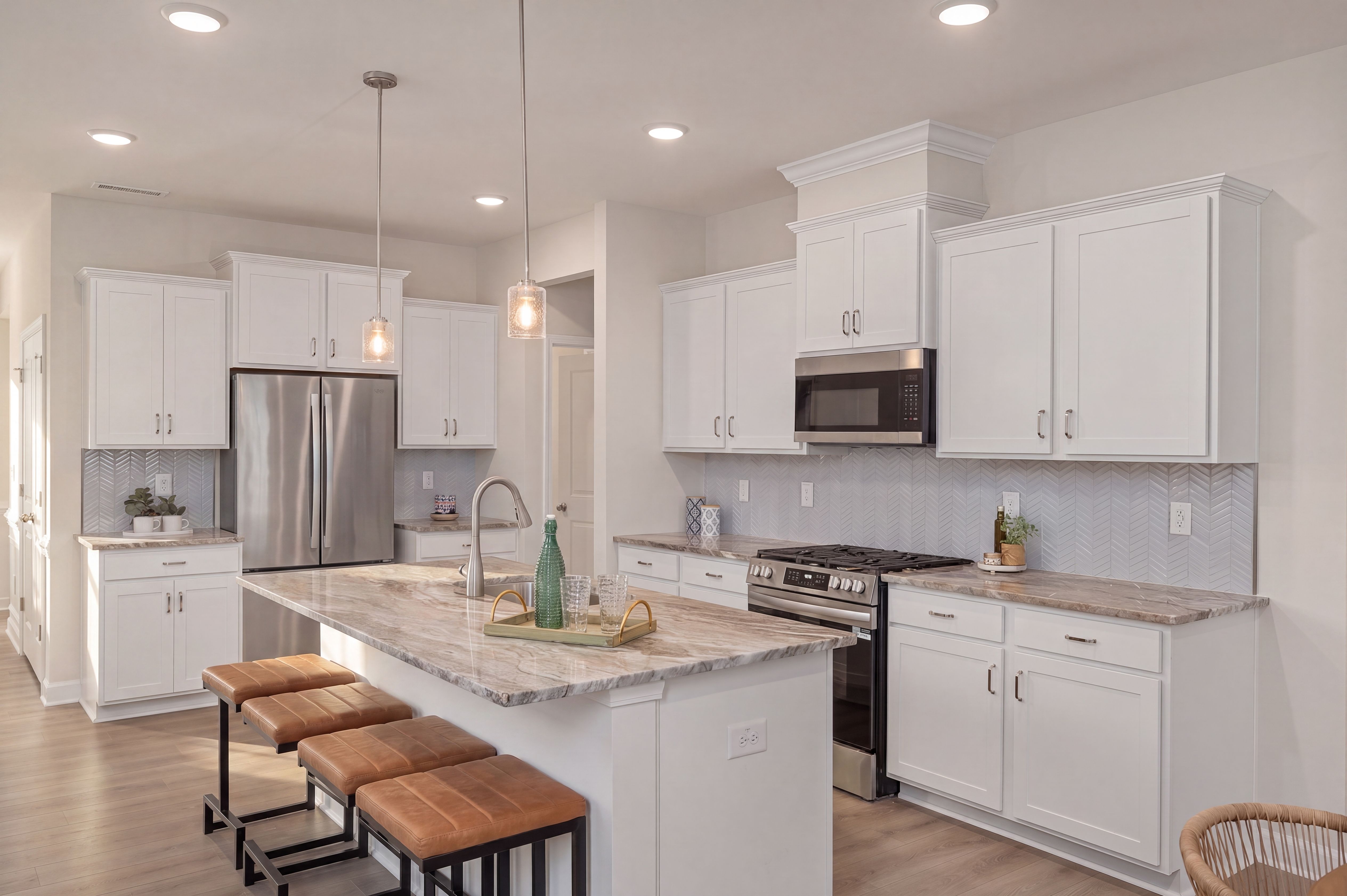 Modern kitchen at Gregory Village in Lillington, NC, featuring white cabinets, stone countertops, and a center island.