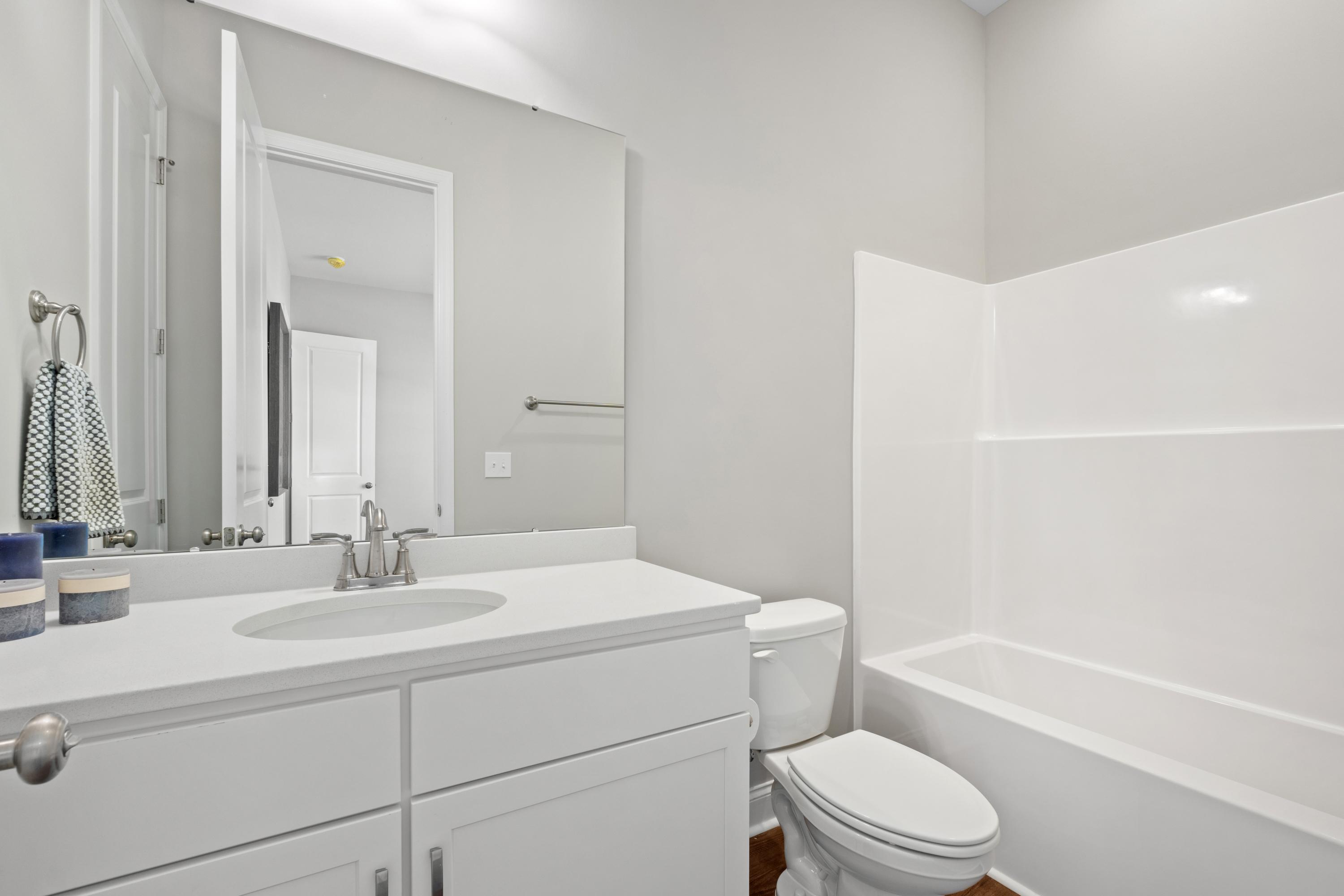 Spacious master bathroom in The Haven D with white double vanity, soaking tub, walk-in shower, and gray walls