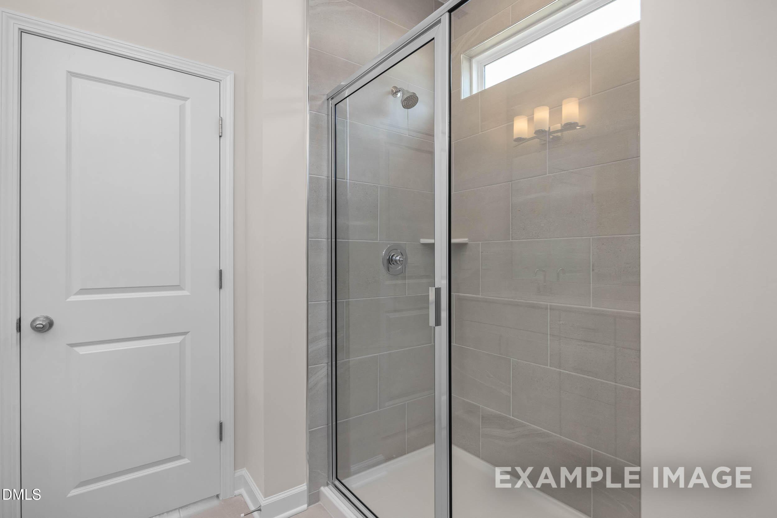 Modern walk-in tile shower in The Franklin C floor plan at Retreat at North Main, Lillington, North Carolina.