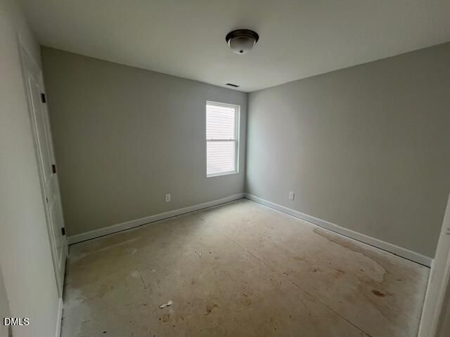 Empty bedroom with light gray walls, window blinds, ceiling fixture, and plywood subfloor in The Adalynn B, Lillington, NC