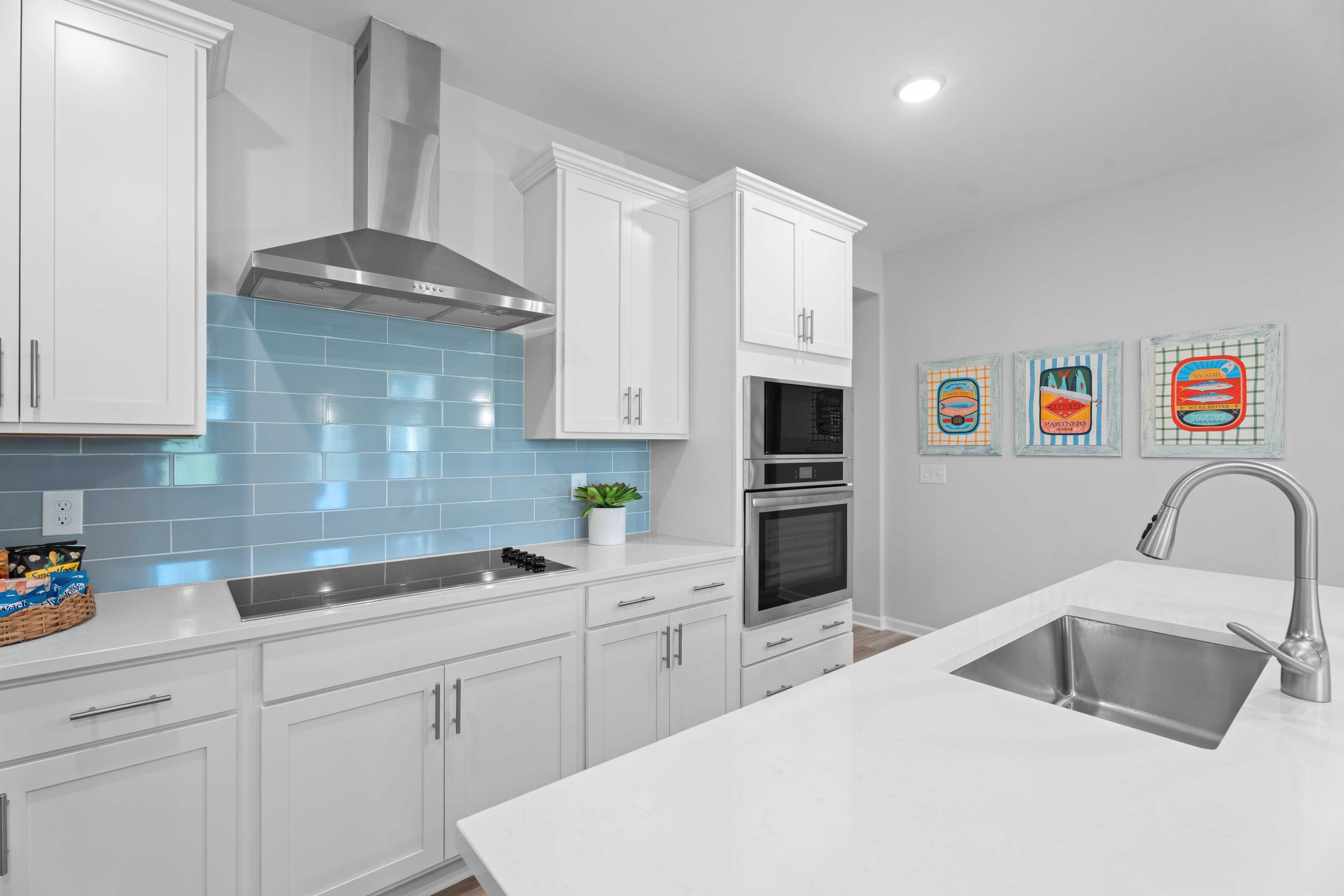 Kitchen with vent hood, stovetop, sink, microwave/oven combo