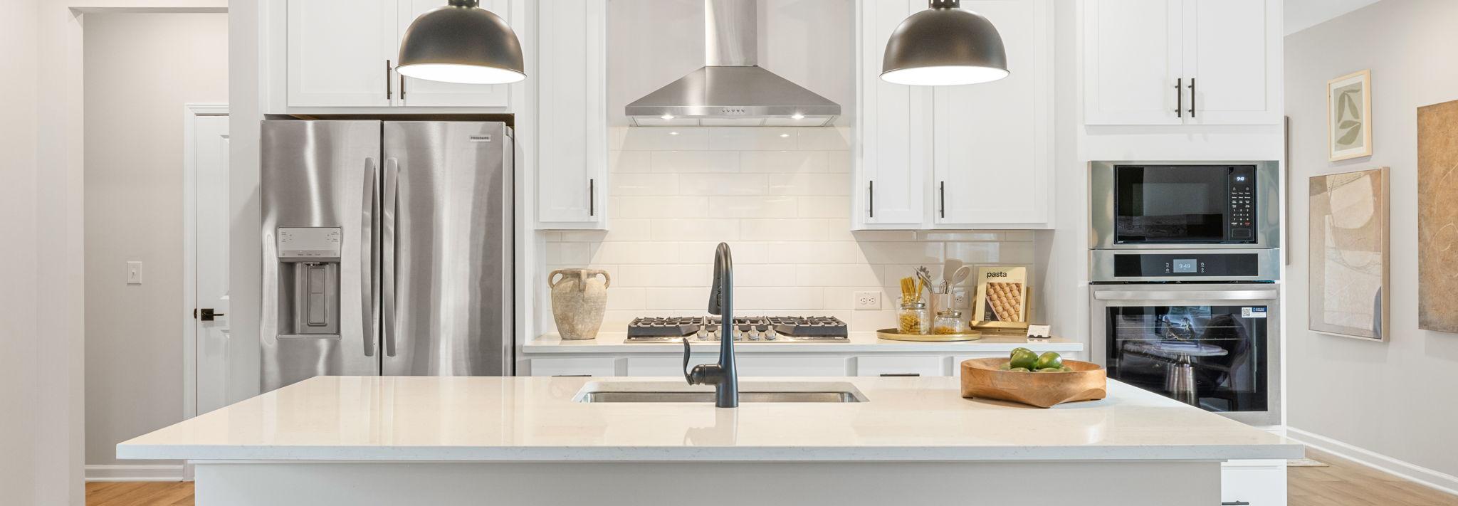 Spacious modern kitchen in Greene Farms Cartersville GA by Davidson Homes with white shaker cabinets, stainless steel appliances, and island