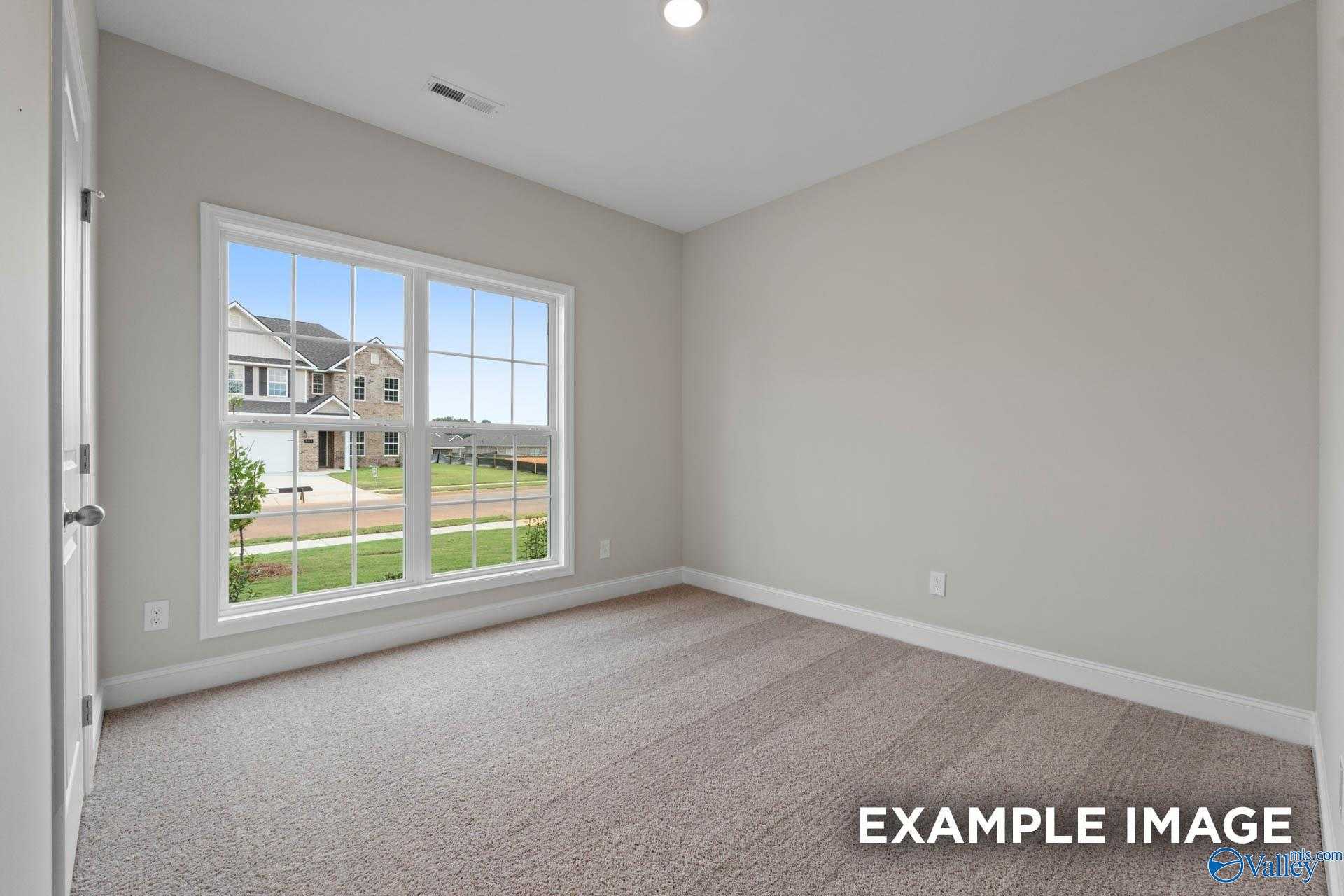 Bright secondary bedroom with large window view of backyard in Davidson Homes The Franklin V, Athens, Alabama