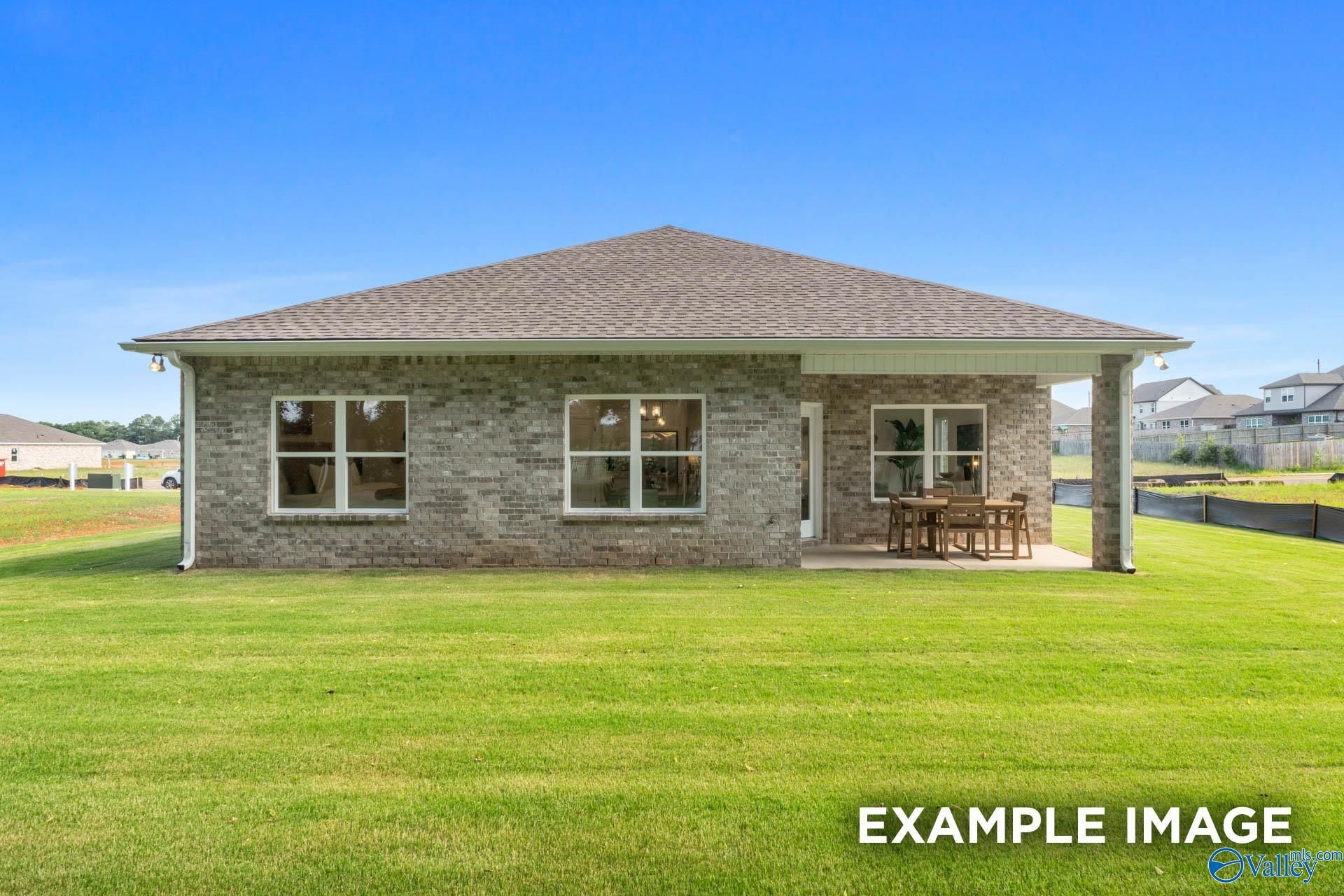 Brick single-story home with covered patio, large windows, and green lawn in Jaguar Hills, Huntsville, Alabama