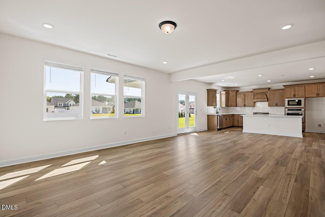 Open-concept living area with hardwood floors and kitchen with wood cabinets in Davidson Homes The Hickory II B, Lillington, NC