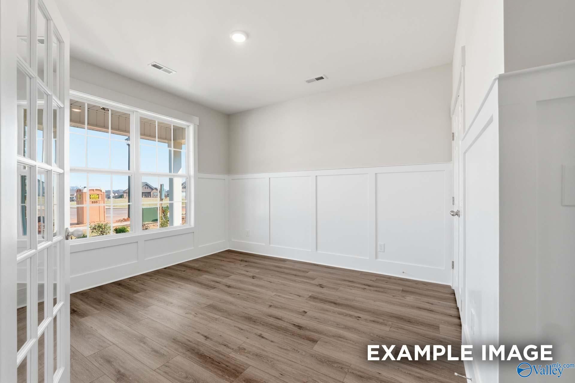 Bright home office with wainscoting and wood flooring in The Harrison floor plan by Davidson Homes in Briercreek.