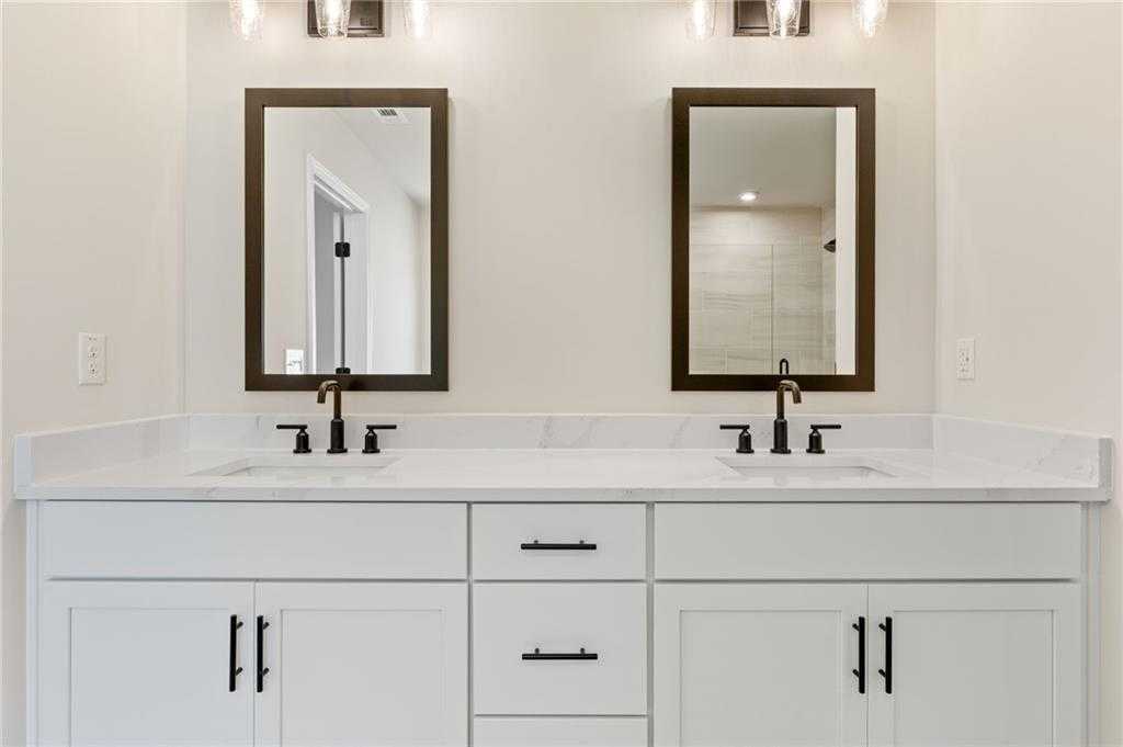 Modern double vanity with white quartz counters, black faucets, and mirrors in master bath of The Hickory E, Davidson Homes, Buford, GA