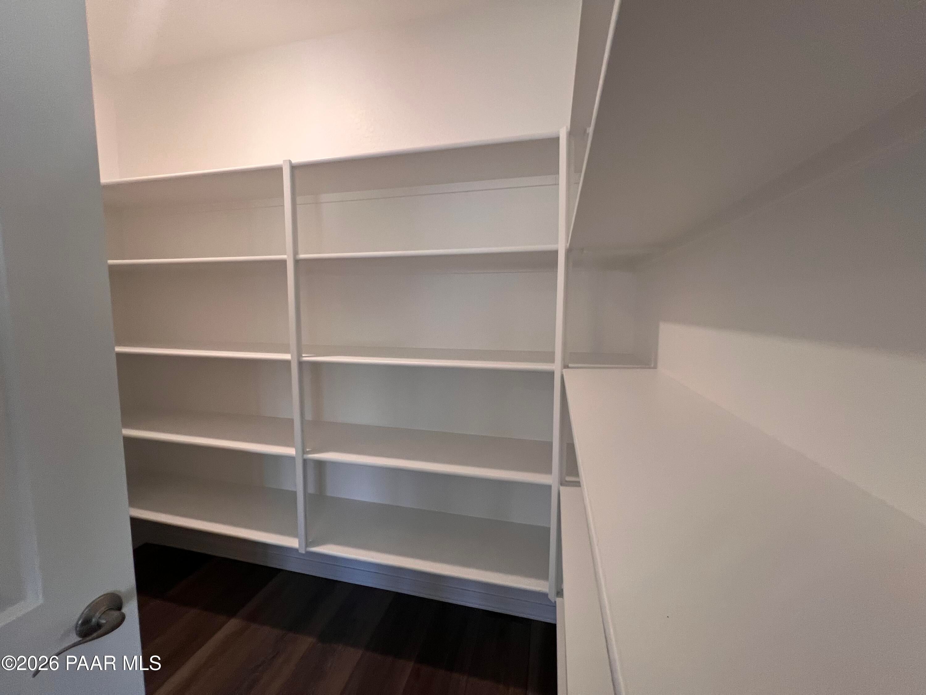 Spacious walk-in closet with white built-in shelving in Davidson Homes The Sunrise II A, Prescott, Arizona