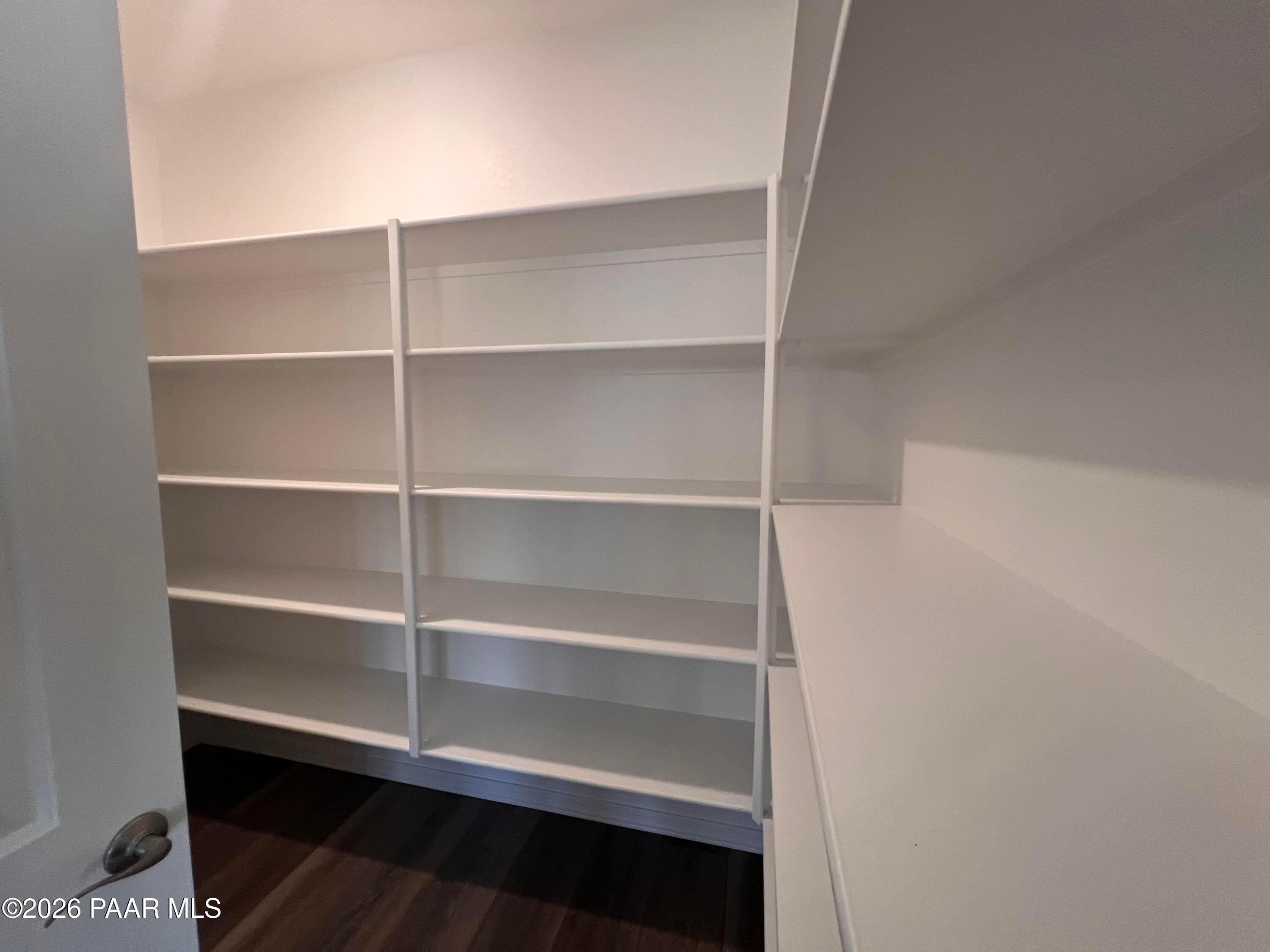 Spacious walk-in closet with white built-in shelving in Davidson Homes The Sunrise II A, Prescott, Arizona