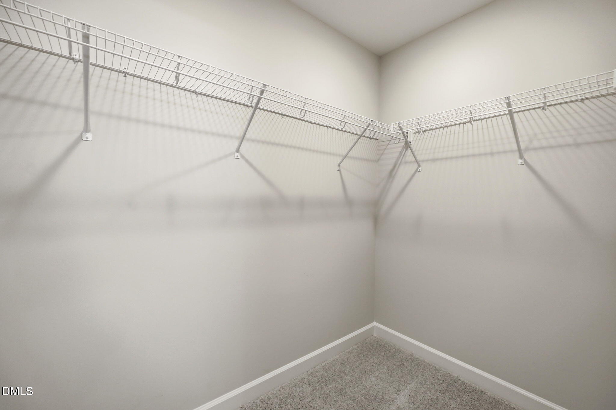 Walk-in closet with white wire shelving in The Avery floor plan at Forestville Yard Townhomes in Knightdale, North Carolina.
