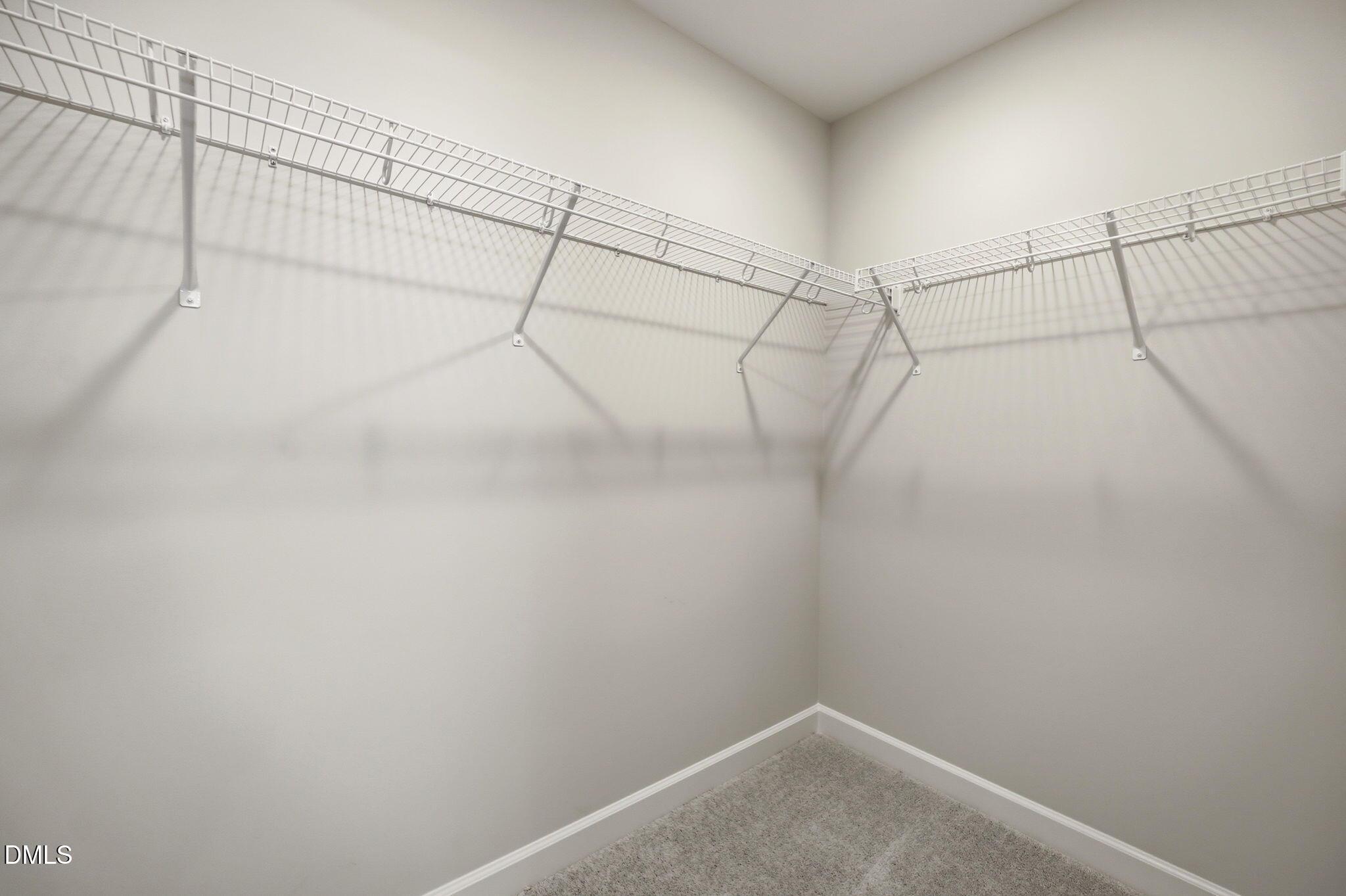 Walk-in closet with white wire shelving in The Avery floor plan at Forestville Yard Townhomes in Knightdale, North Carolina.