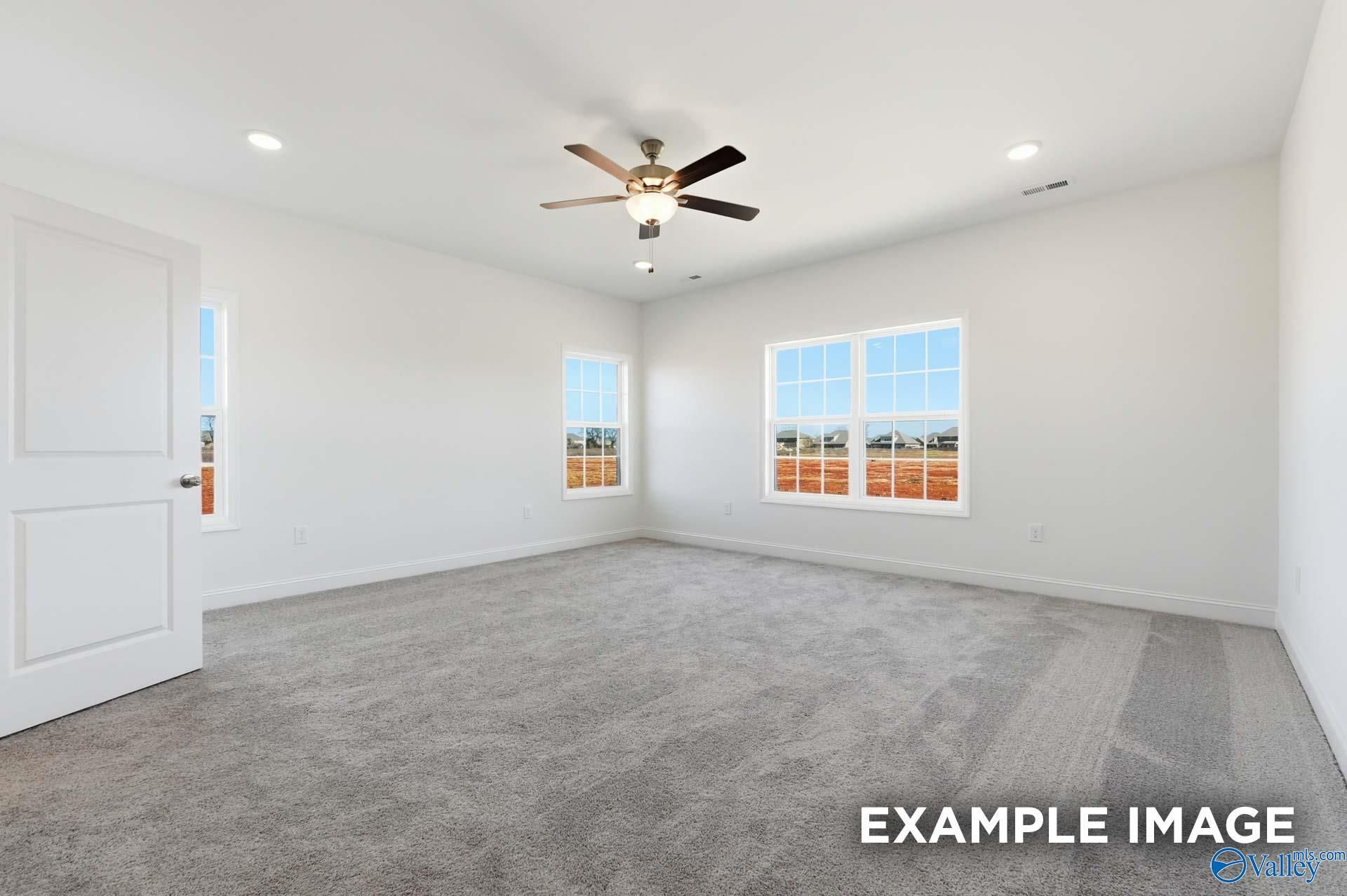 Bright, carpeted bedroom with ceiling fan in The Valencia floor plan by Davidson Homes in Briercreek, Meridianville, AL.
