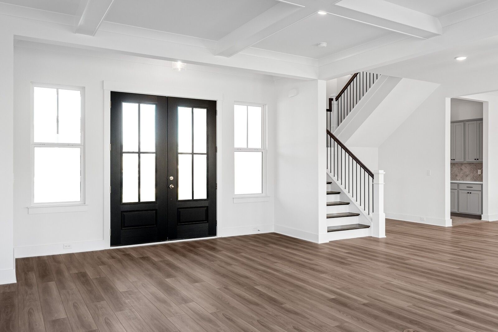 Grand entry foyer with black double doors, hardwood floors, and elegant staircase in Davidson Homes The Alston A, Murfreesboro