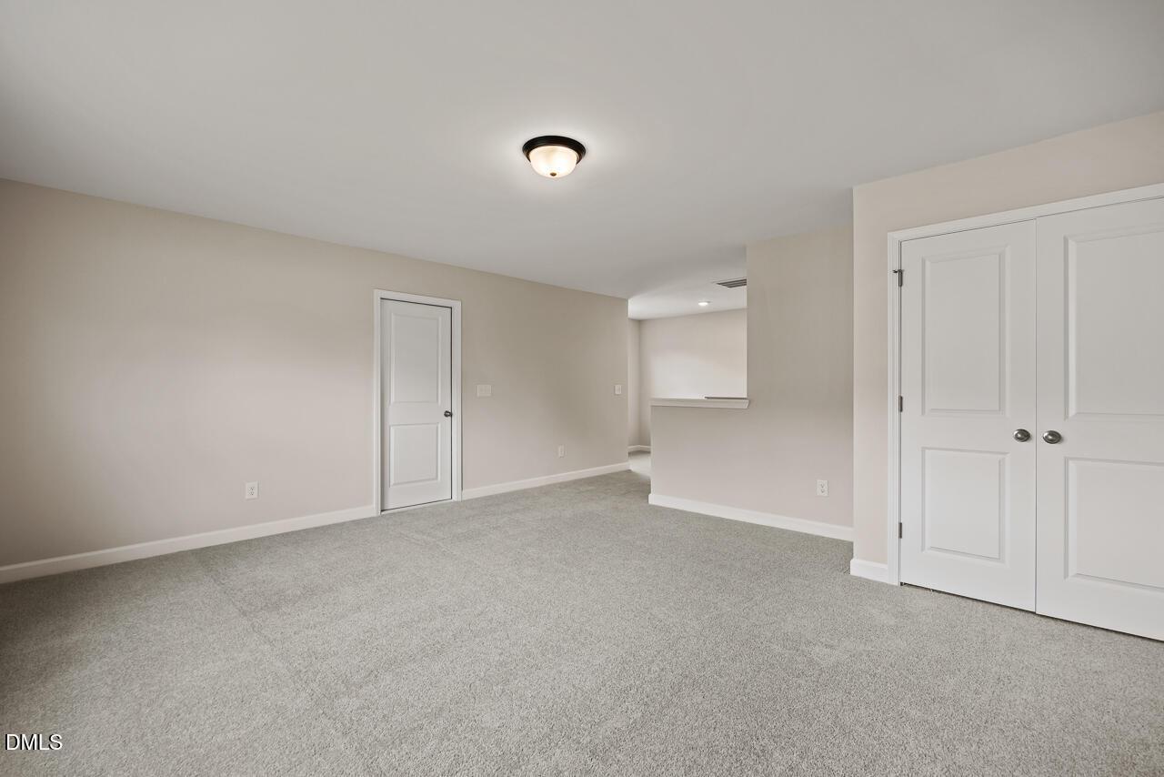 Spacious carpeted loft with white doors in The Ash C floor plan by Davidson Homes in Woodland Crossing, Zebulon, NC.