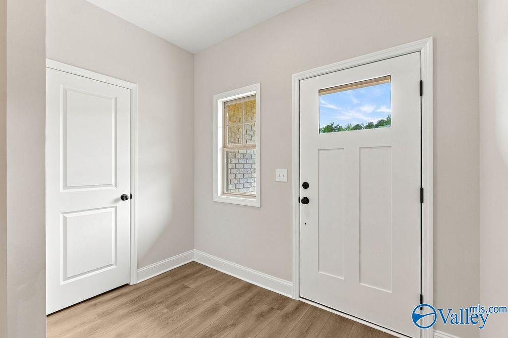 Bright entryway with wood-style flooring and white front door in The Camilla C floor plan at The Retreat at Cain Park.