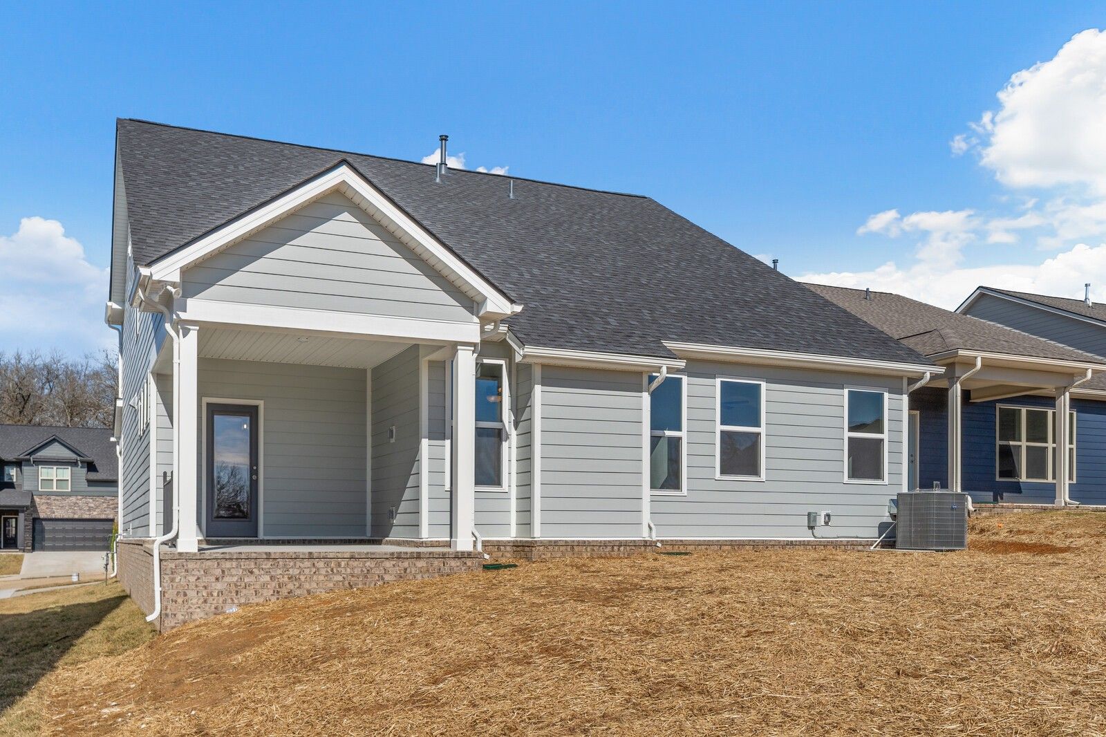 Two-story gray home with covered front porch, white columns, and modern windows in Woods Crossing, Gallatin, Tennessee