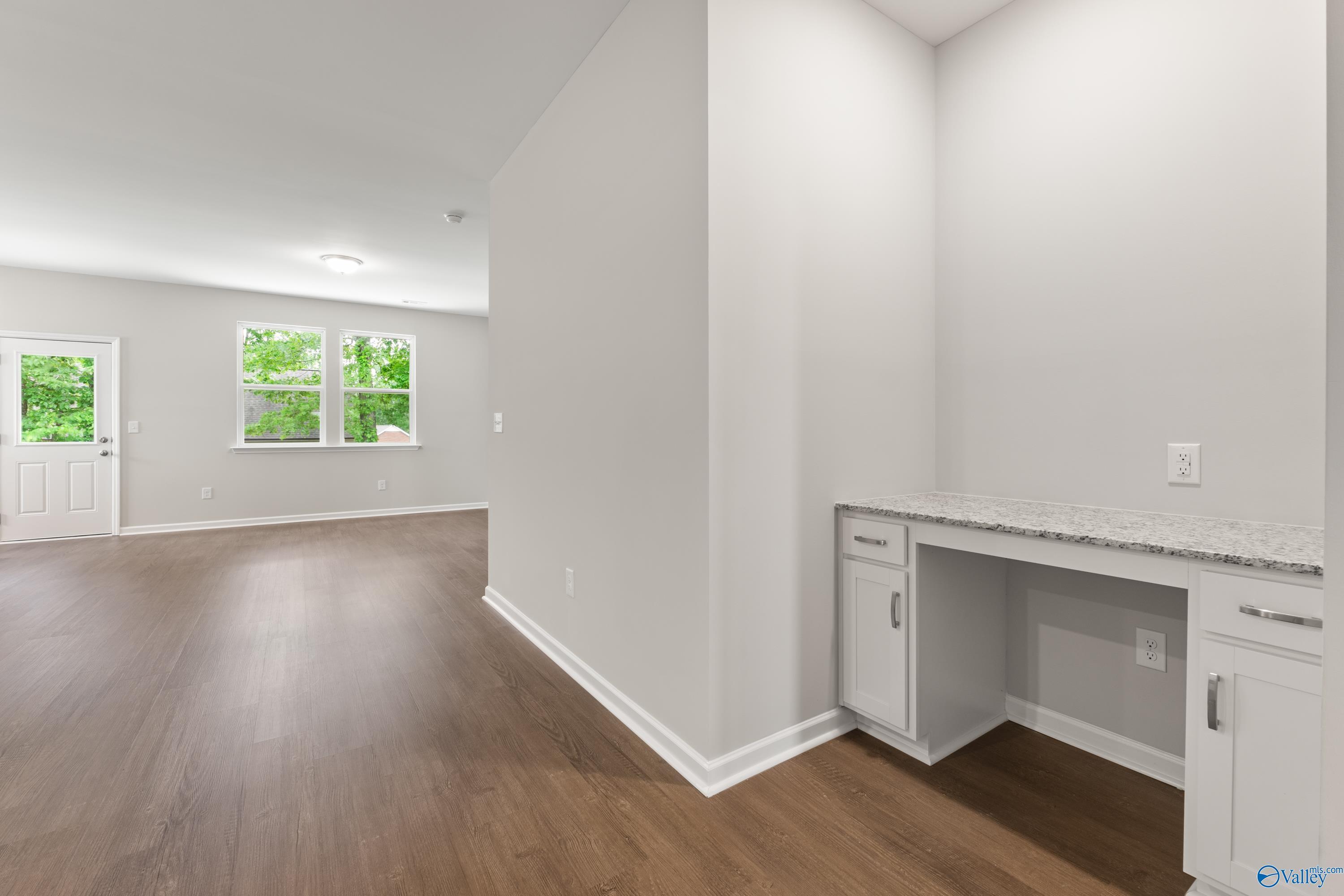 Built-in white desk with quartz countertop and cabinets in open foyer of Davidson Homes The Phoenix 3-bedroom in Fayetteville, TN