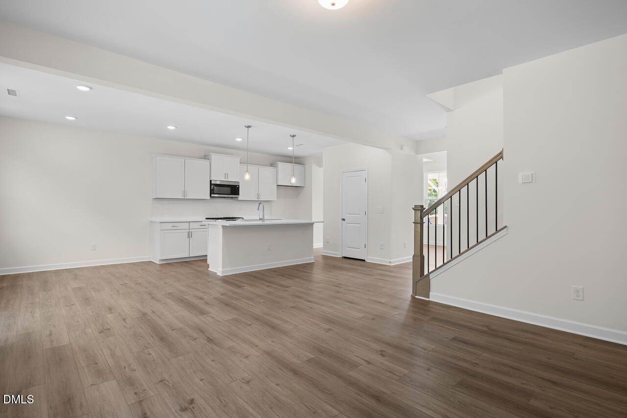 Open-concept kitchen with white cabinetry and center island in Davidson Homes The Willow B floor plan, Zebulon, NC