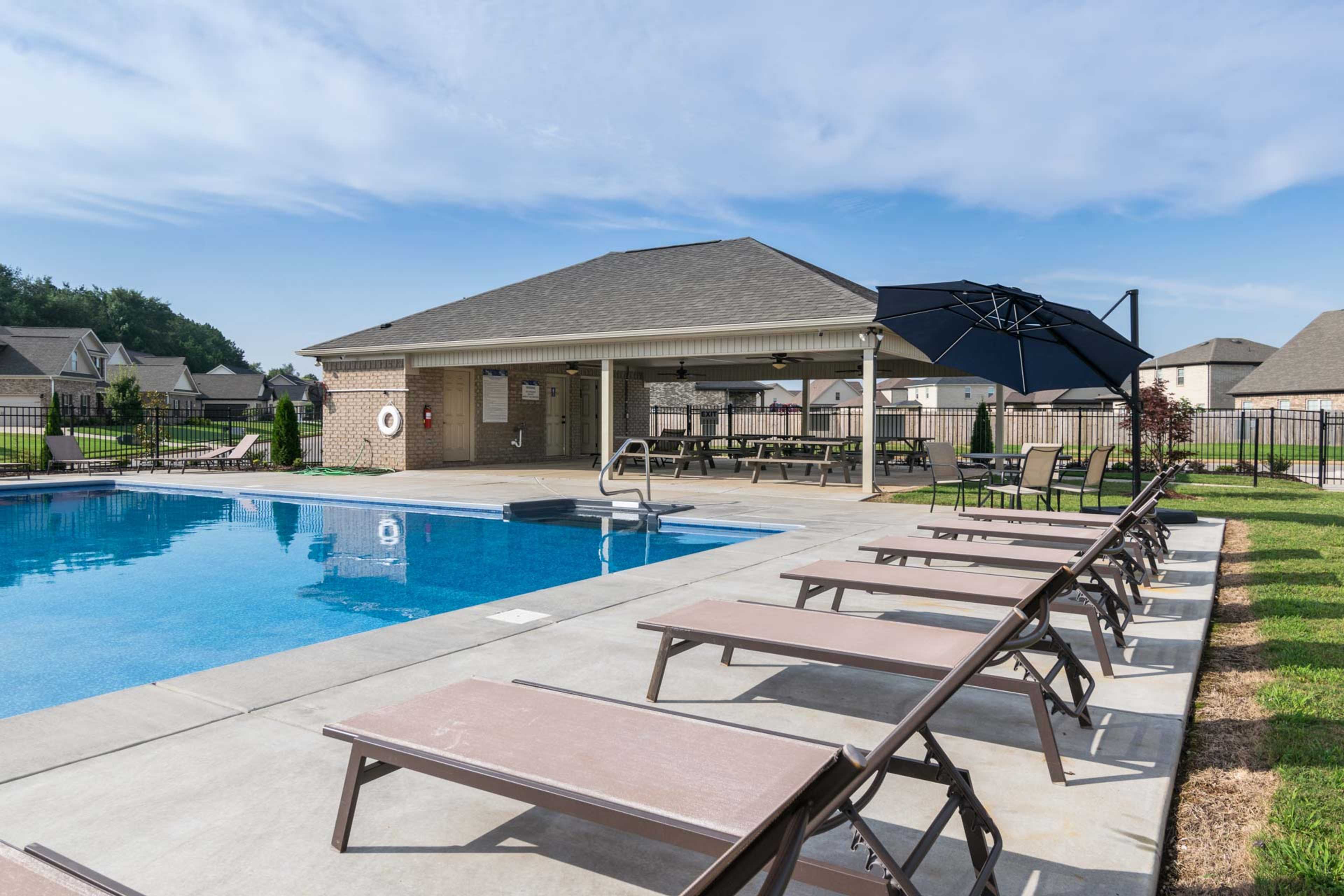 Community swimming pool at Ivy Hills in Toney Alabama with lounge chairs, covered pavilion, and picnic tables