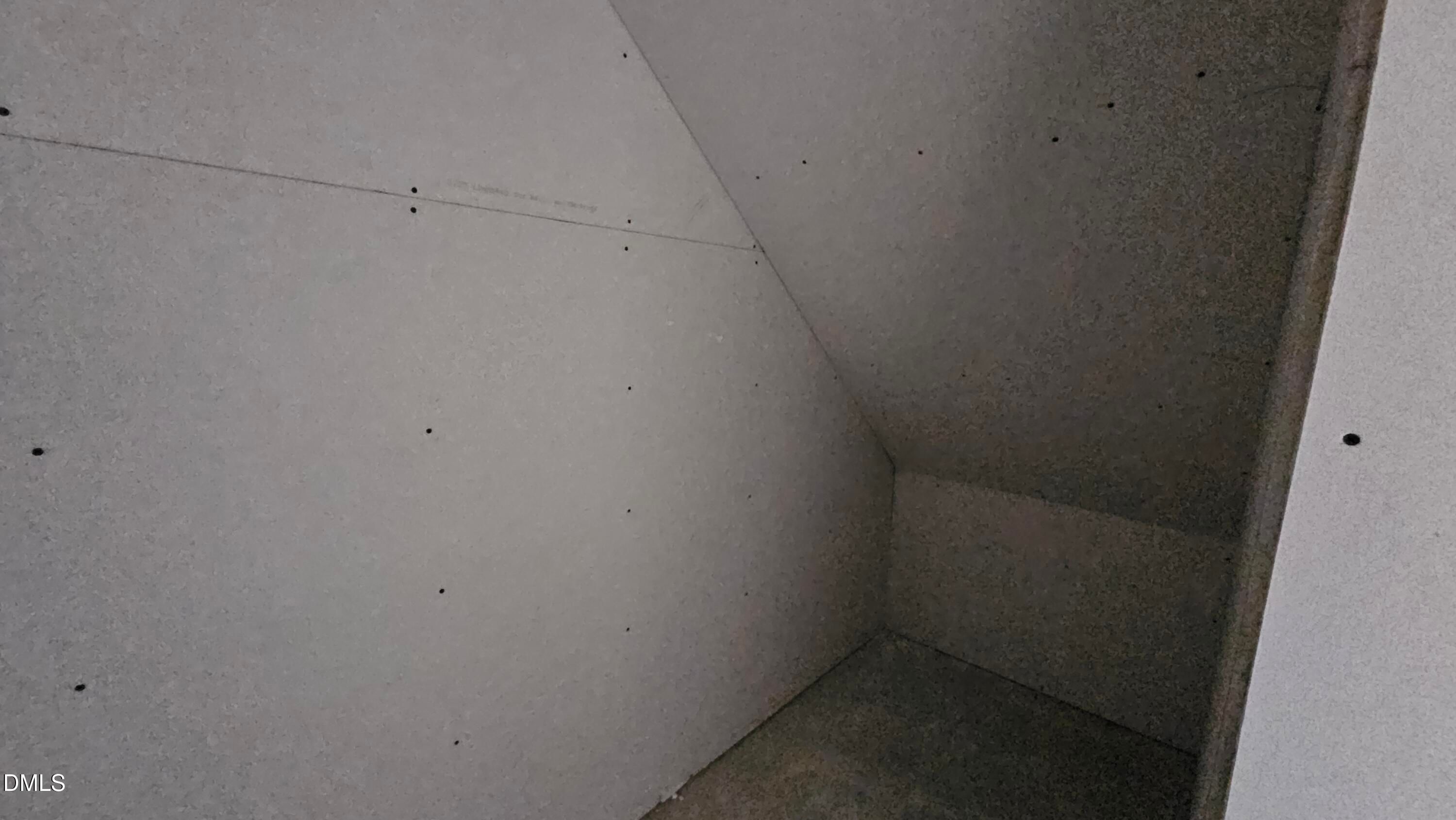 Unfinished drywall storage space under stairs in The Graham Interior floor plan by Davidson Homes in Fuquay-Varina, NC.