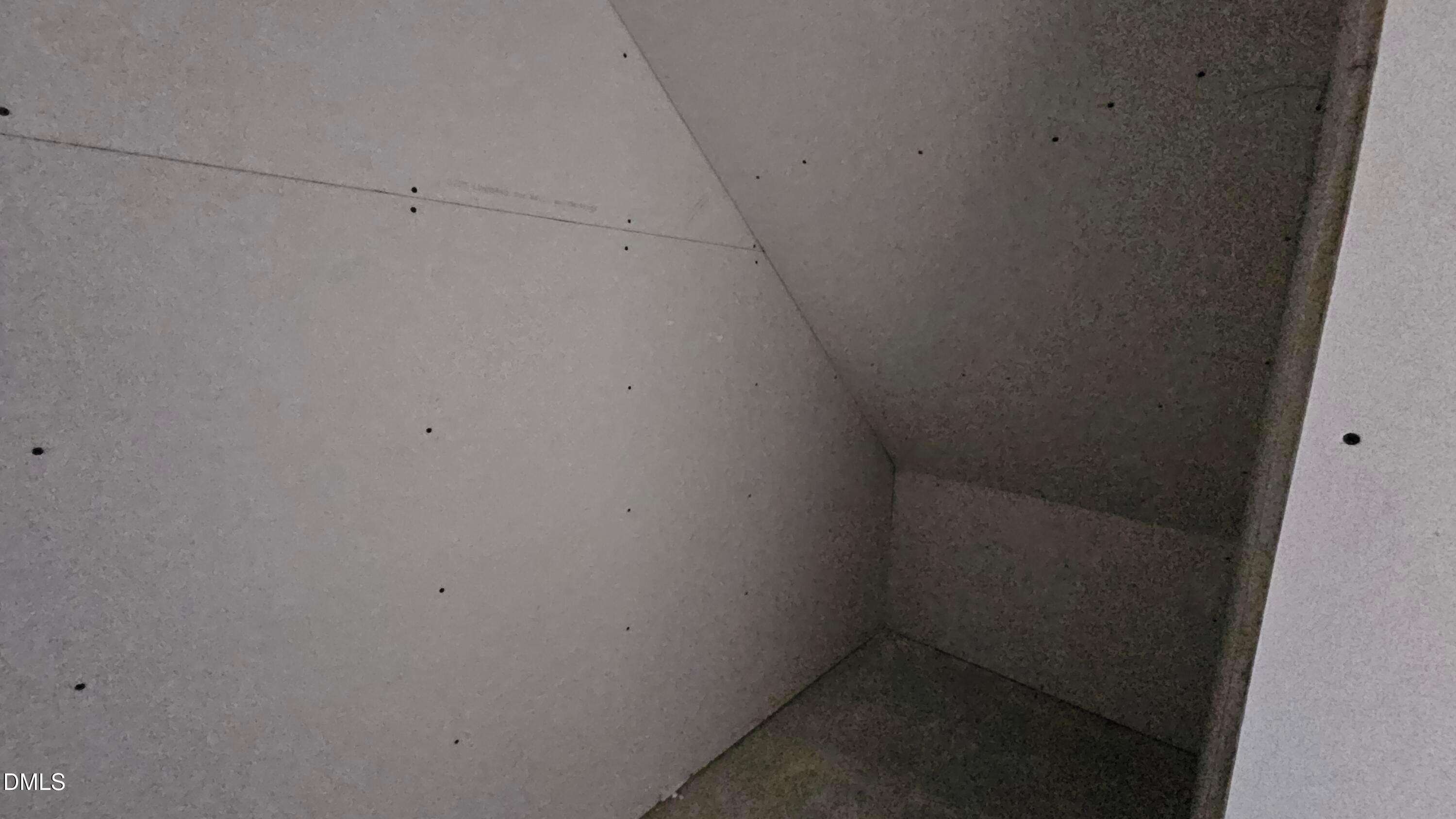 Unfinished drywall storage space under stairs in The Graham Interior floor plan by Davidson Homes in Fuquay-Varina, NC.
