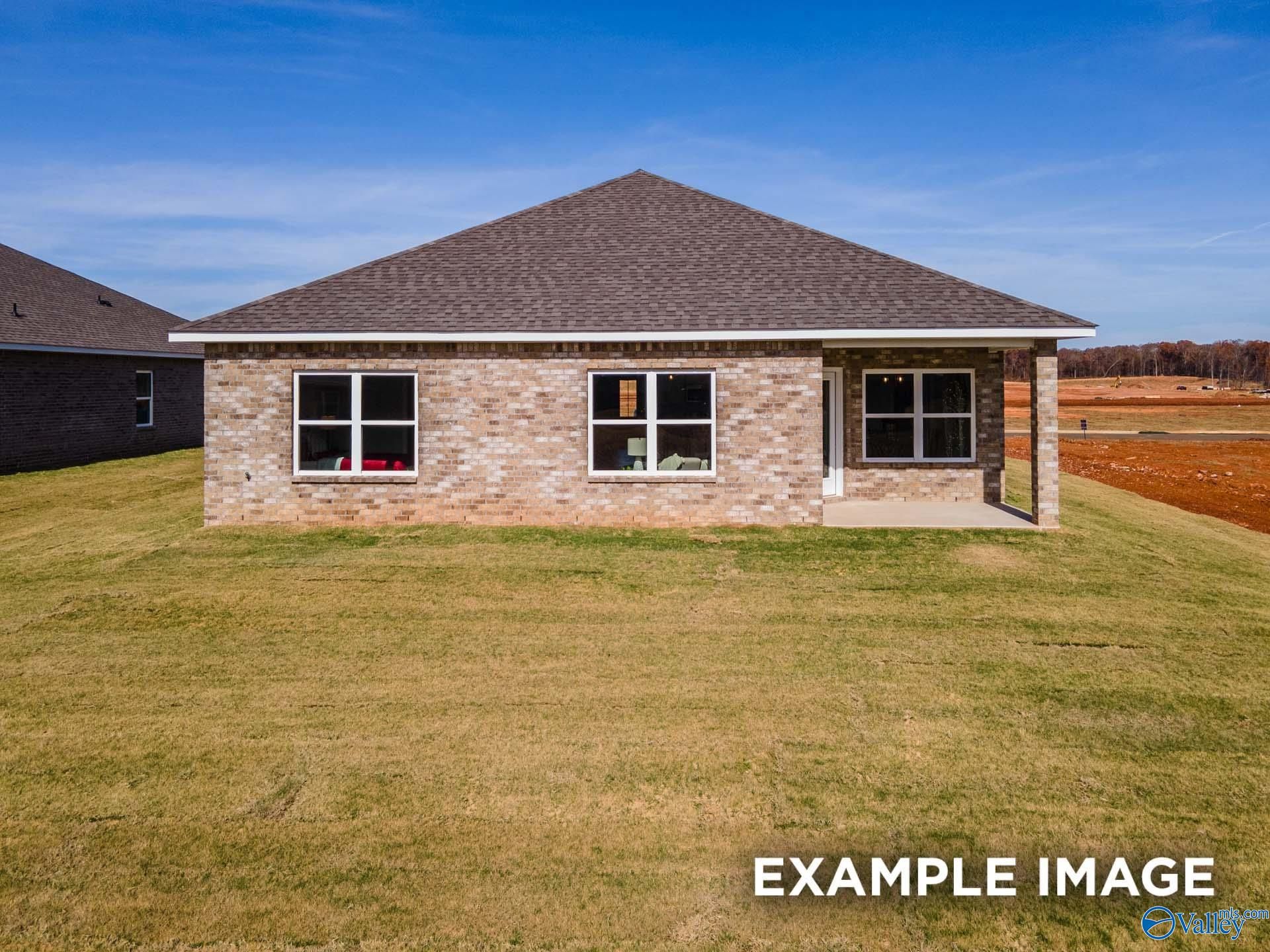 Single-story brick home with gabled roof, covered porch, and large windows on lush green lawn in Walker's Hill, Meridianville, Alabama
