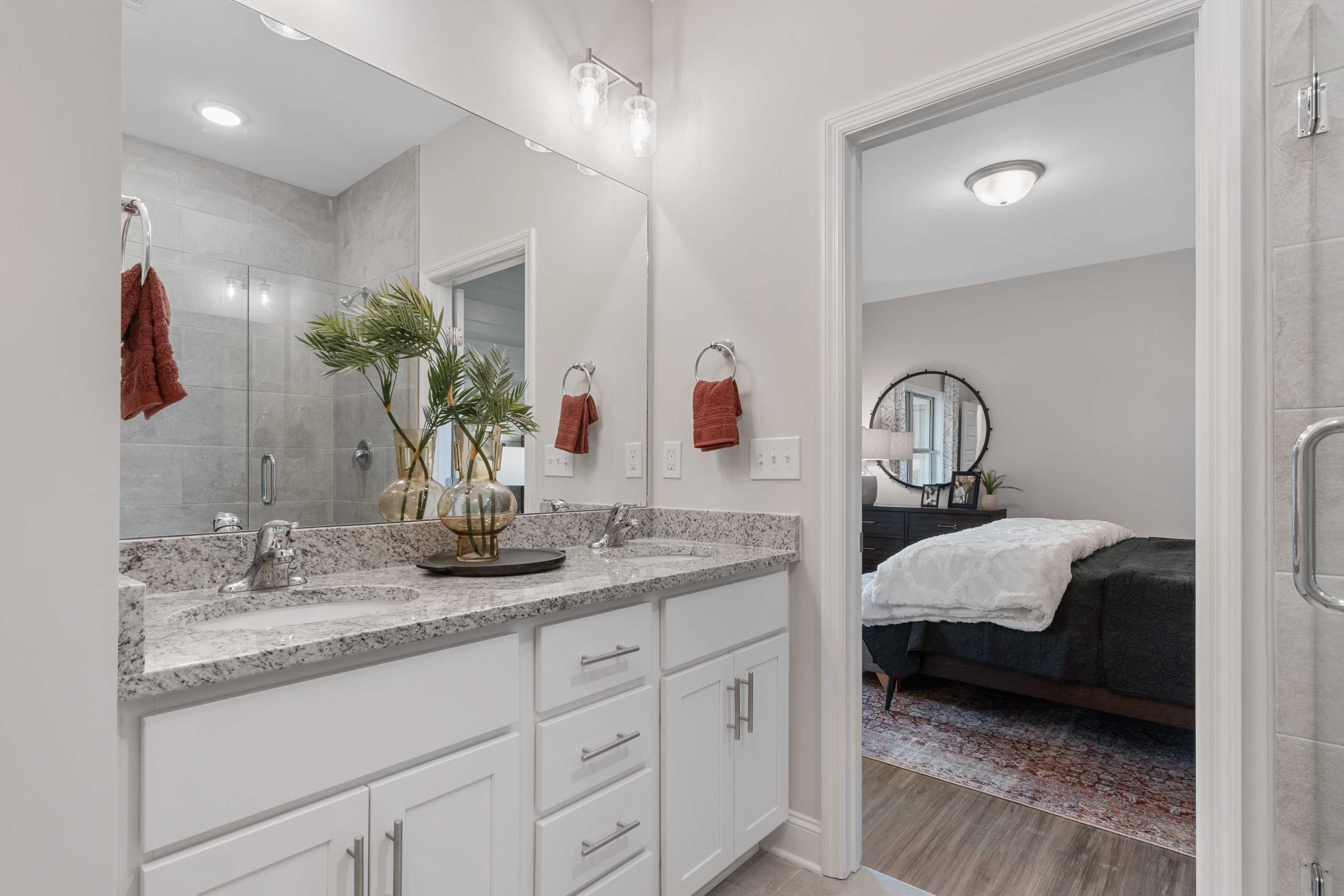 Modern master bathroom at The Retreat at Cain Park in Hartselle AL with double vanity, quartz counters and adjacent bedroom