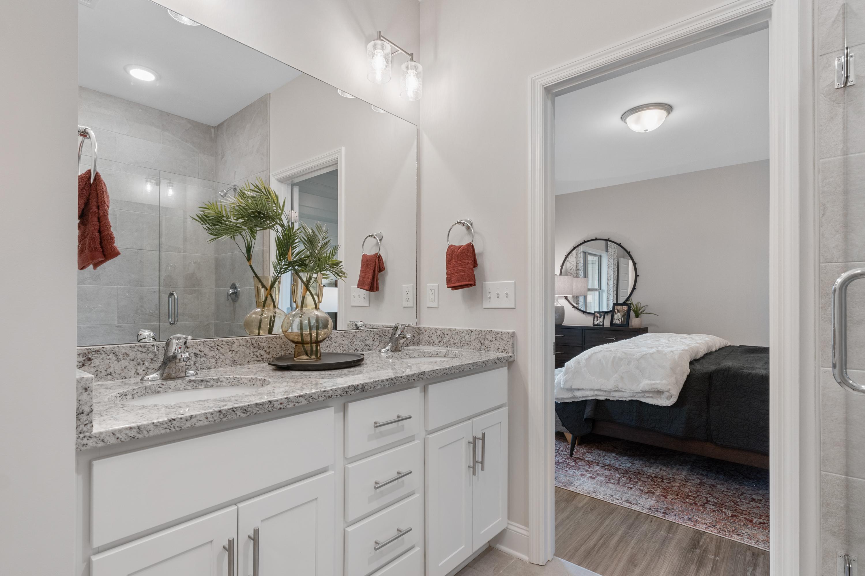 Modern master bathroom at The Retreat at Cain Park in Hartselle AL with double vanity, quartz counters and adjacent bedroom