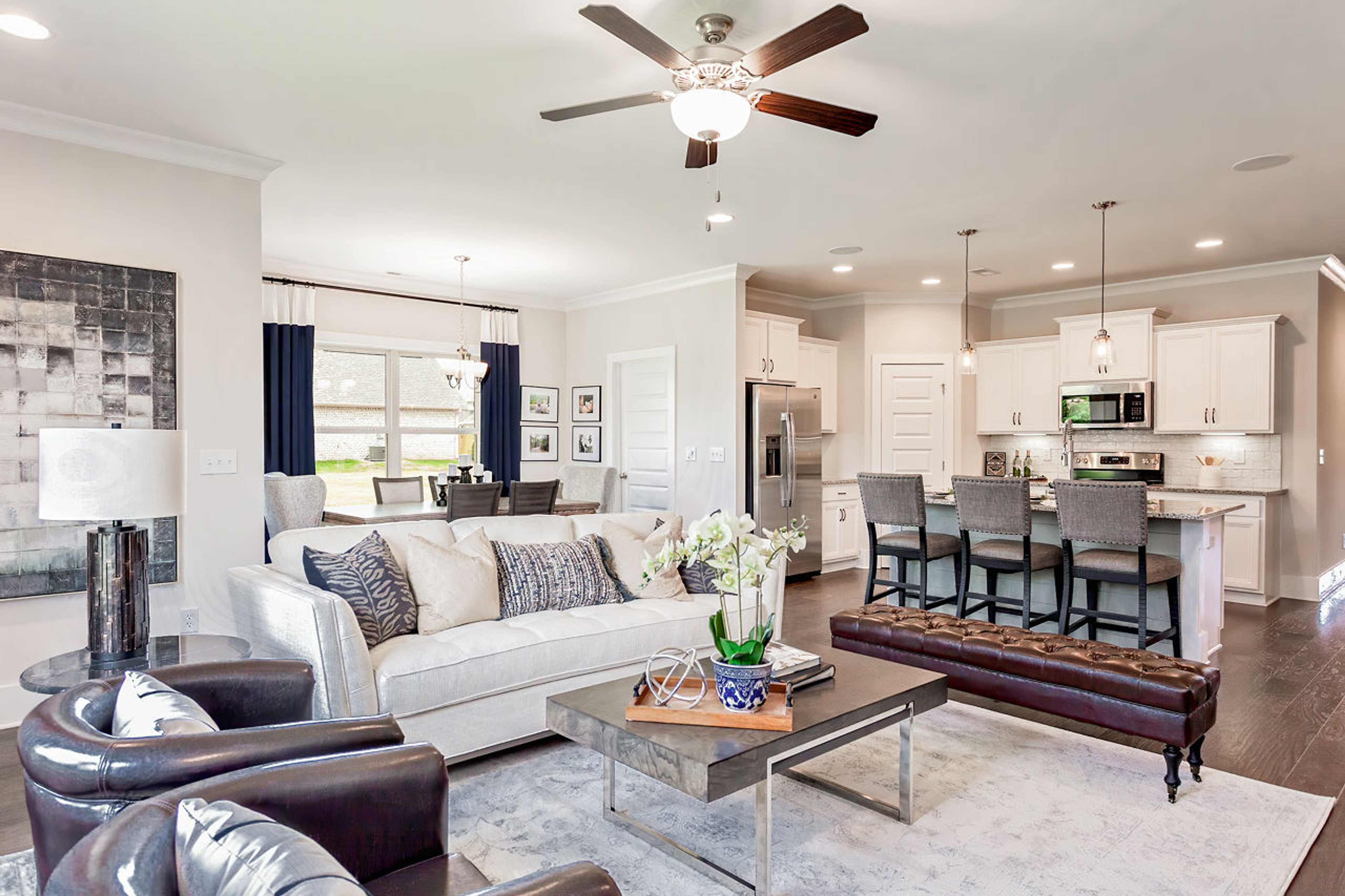 Open-concept living room and kitchen at Williams Pointe in Huntsville AL with white sofa, bar island, hardwood floors